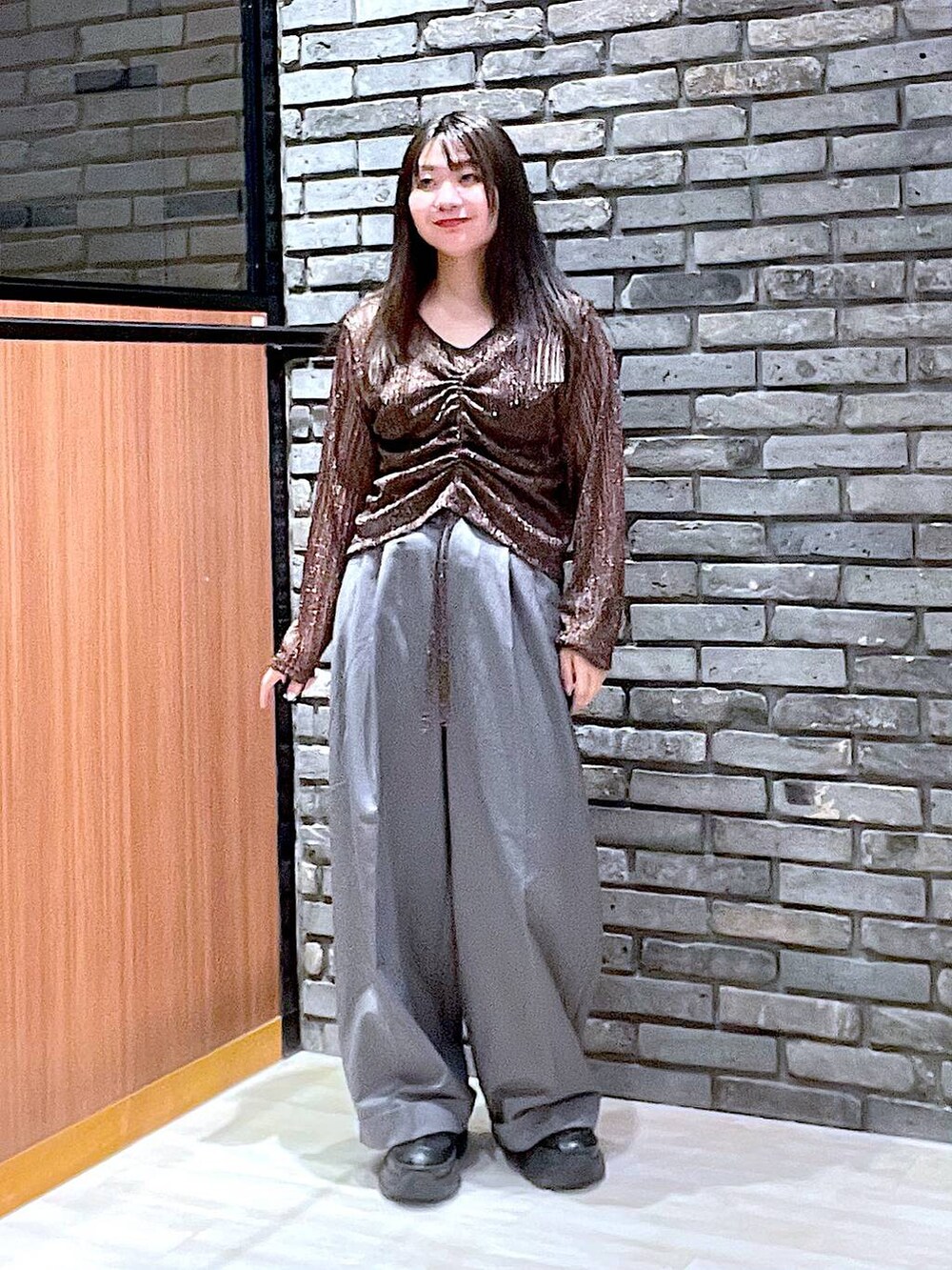 ブラック系のスニーカー、グレー系のスラックス、ブラウン系のTシャツ/カットソーを着用したレディースの夏コーディネートの4枚目の写真