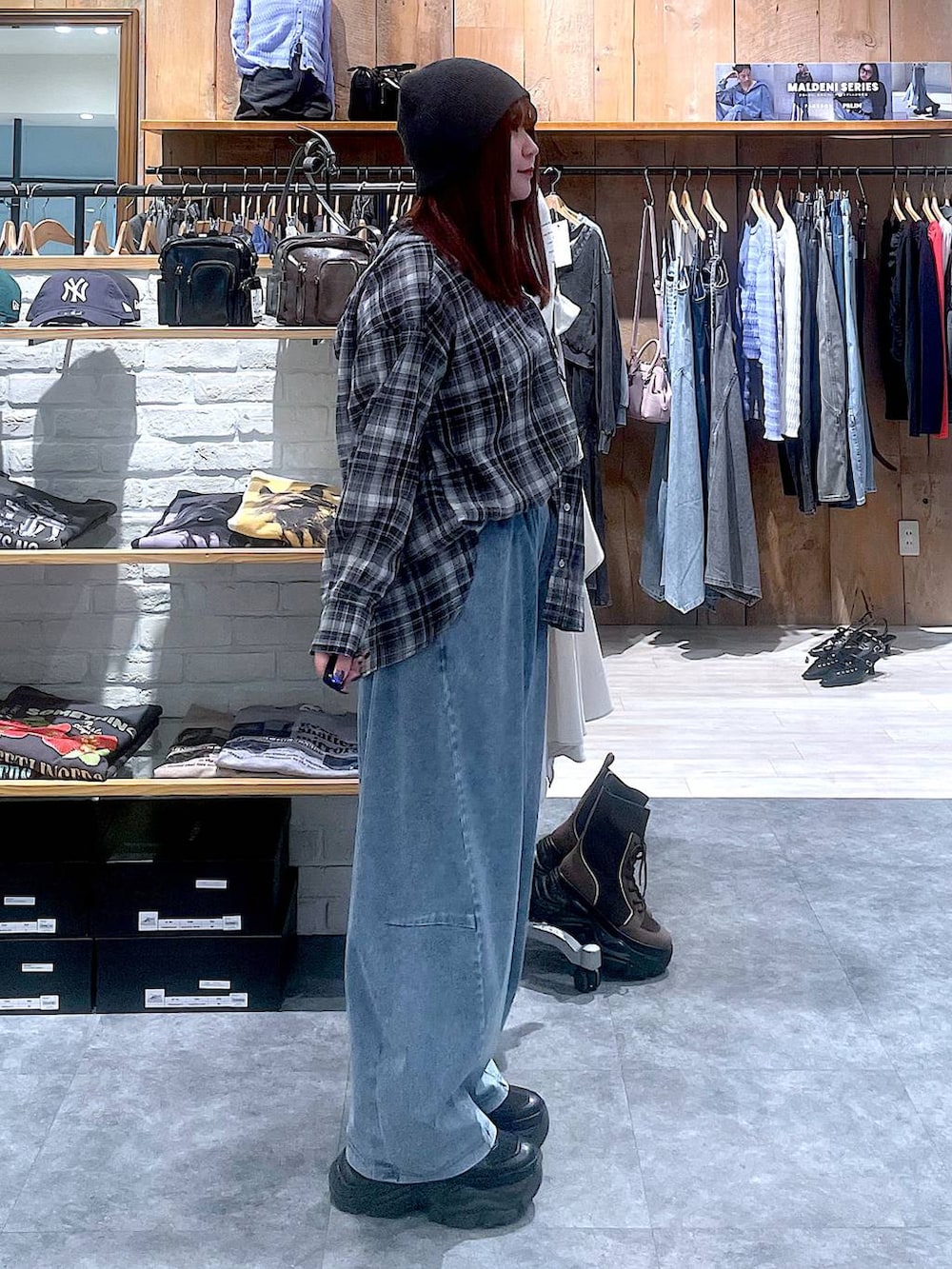 ブラック系のスニーカー、ブルー系のデニムパンツ、ブラック系のシャツ/ブラウスを着用したレディースの春コーディネートの3枚目の写真