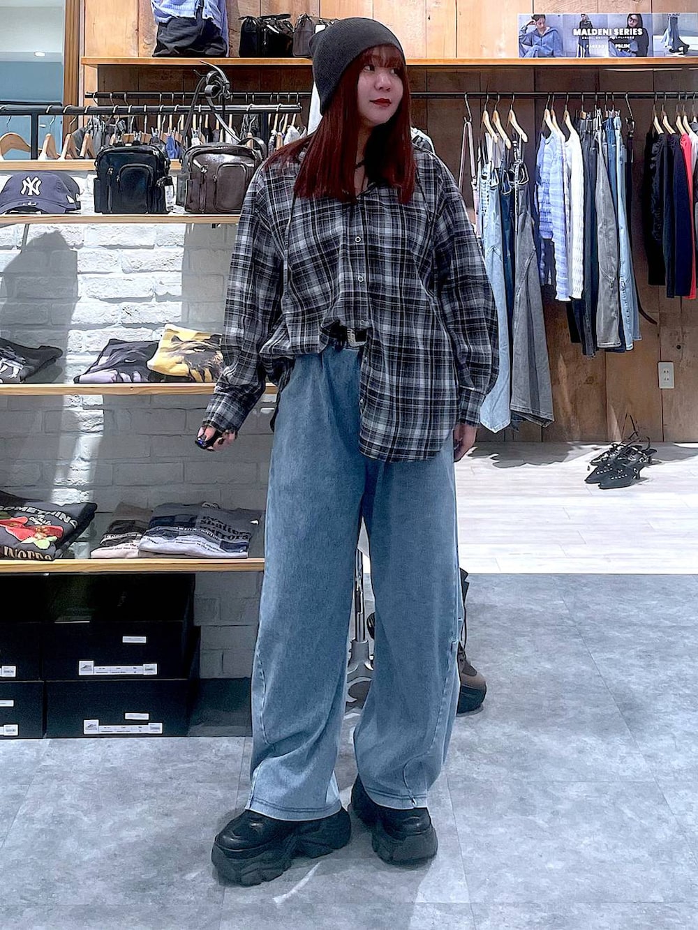 ブラック系のスニーカー、ブルー系のデニムパンツ、ブラック系のシャツ/ブラウスを着用したレディースの春コーディネートの2枚目の写真