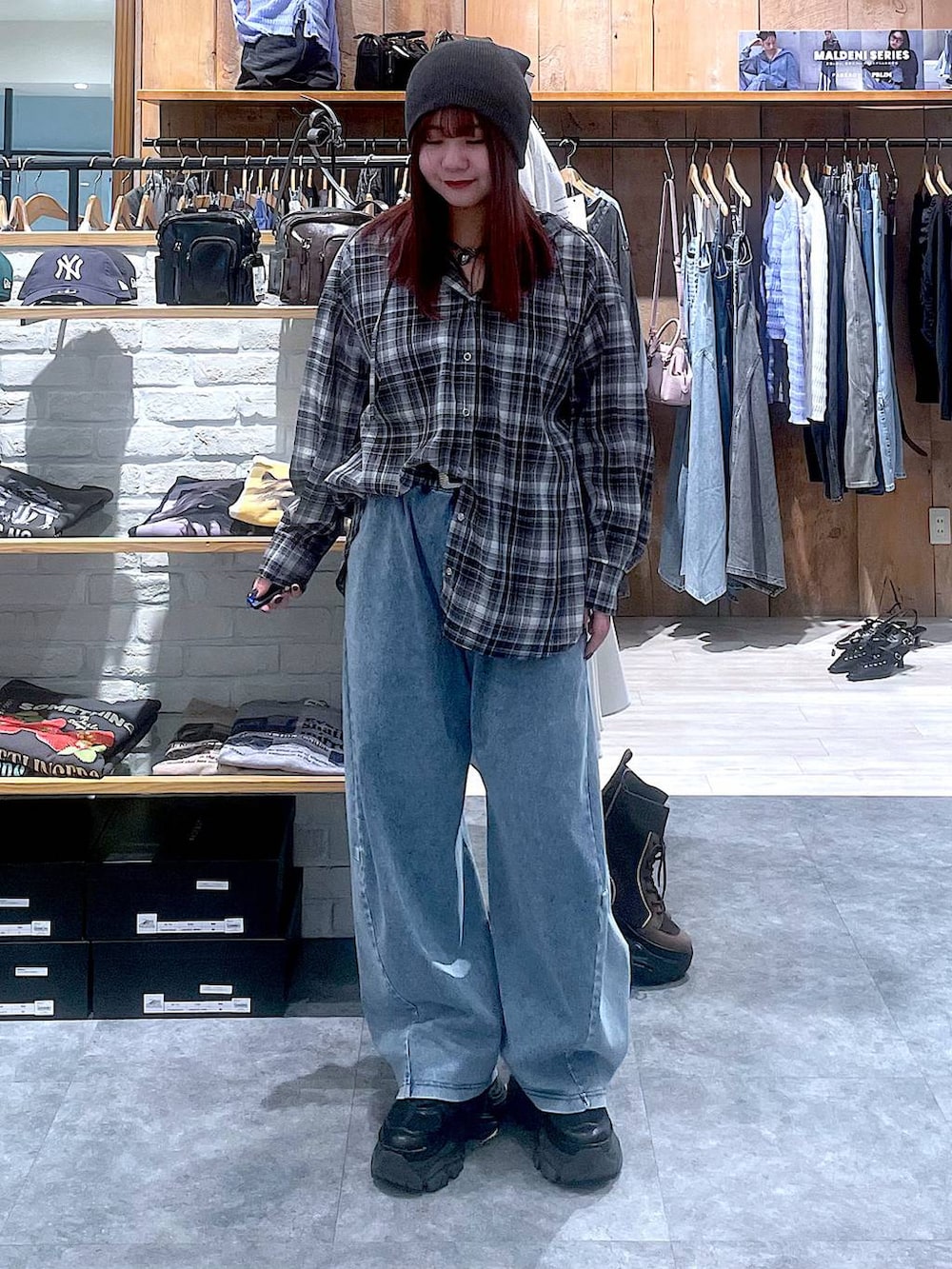 ブラック系のスニーカー、ブルー系のデニムパンツ、ブラック系のシャツ/ブラウスを着用したレディースの春コーディネートの7枚目の写真