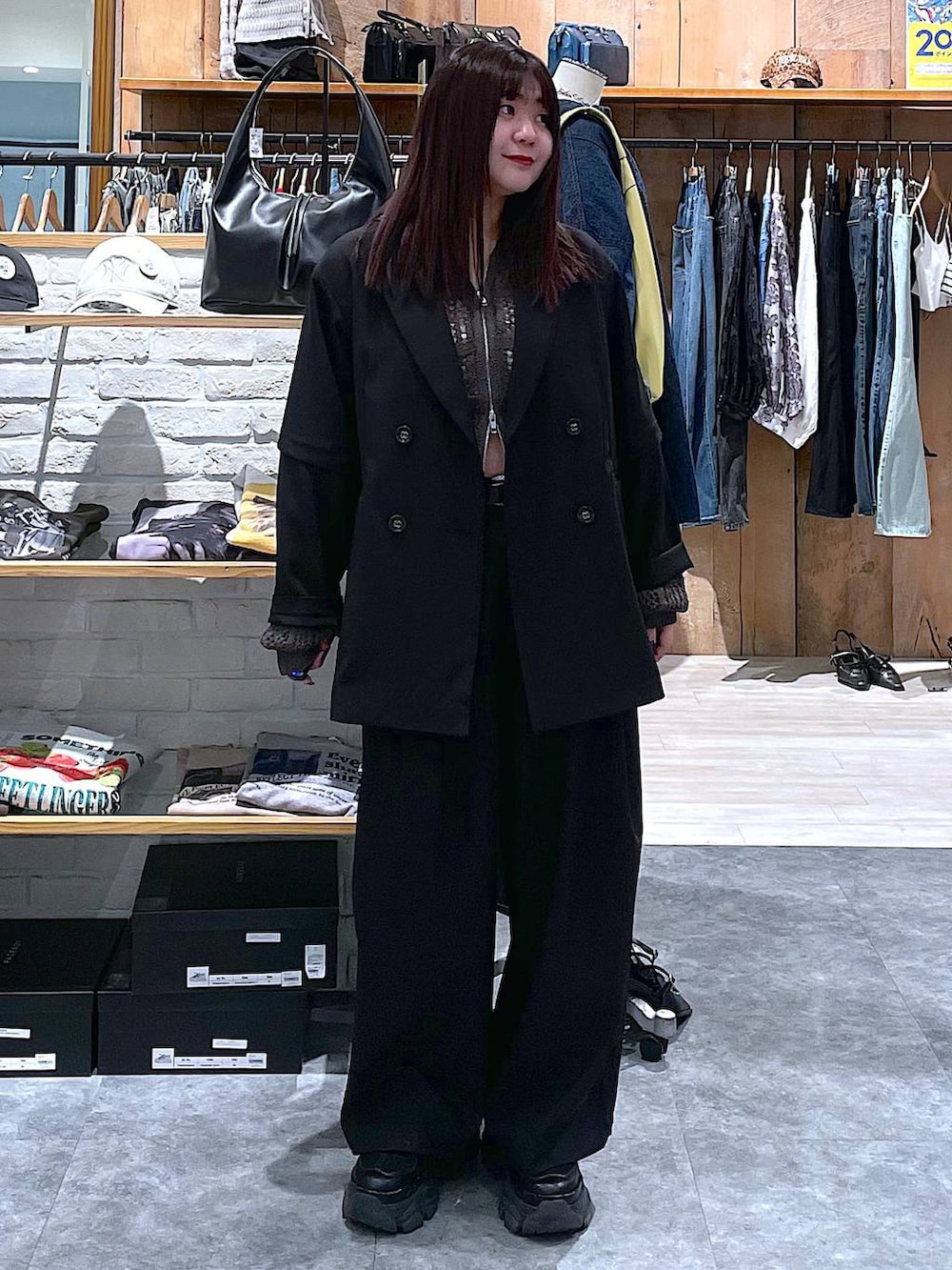 ブラック系のスニーカー、ブラック系のテーラードジャケット、グレー系のパーカーを着用したレディースの春コーディネートの2枚目の写真