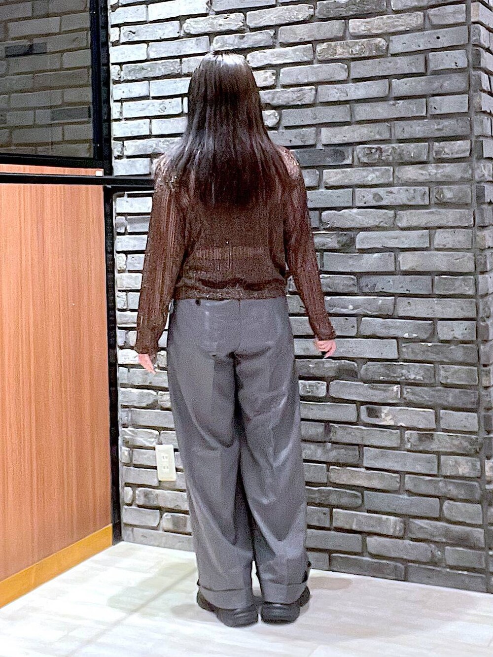 ブラック系のスニーカー、グレー系のスラックス、ブラウン系のTシャツ/カットソーを着用したレディースの夏コーディネートの2枚目の写真