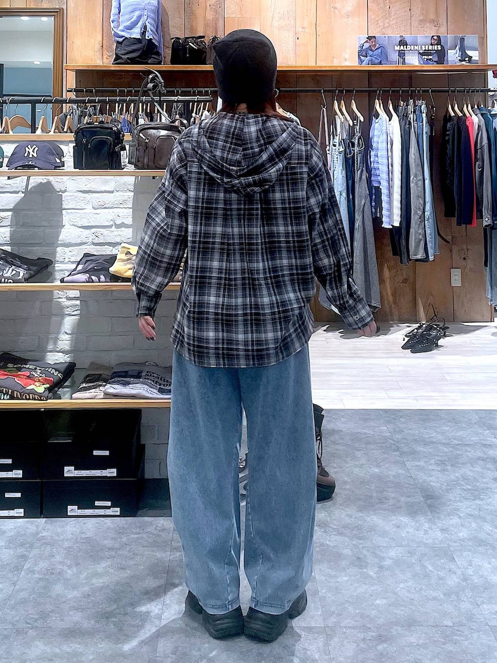 ブラック系のスニーカー、ブルー系のデニムパンツ、ブラック系のシャツ/ブラウスを着用したレディースの春コーディネートの5枚目の写真