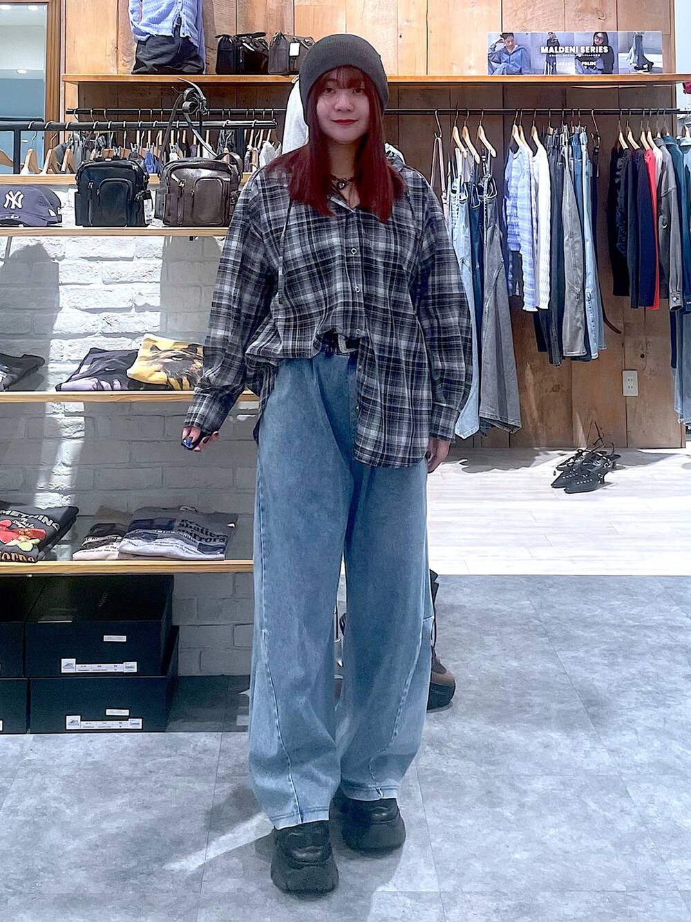 ブラック系のスニーカー、ブルー系のデニムパンツ、ブラック系のシャツ/ブラウスを着用したレディースの春コーディネートの6枚目の写真