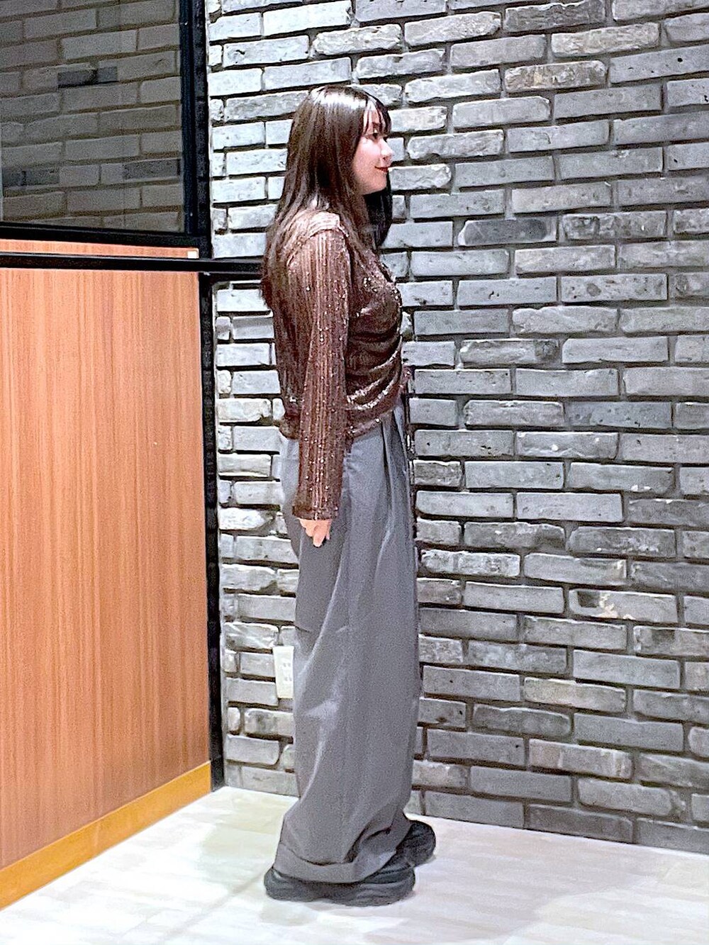 ブラック系のスニーカー、グレー系のスラックス、ブラウン系のTシャツ/カットソーを着用したレディースの夏コーディネートの3枚目の写真