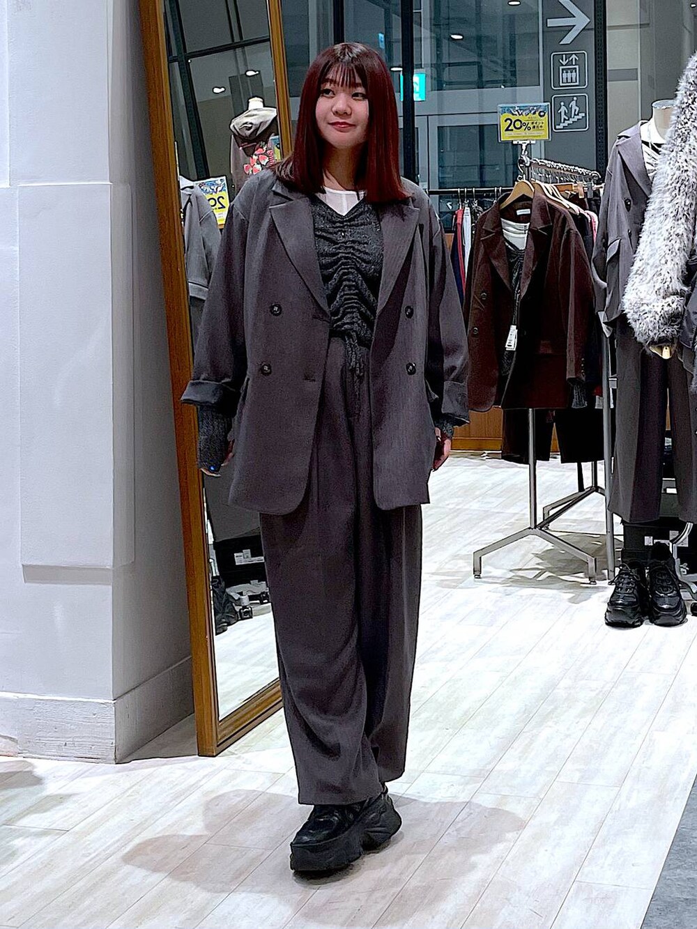 ブラック系のスニーカー、ホワイト系のTシャツ/カットソー、グレー系のテーラードジャケットを着用したレディースの秋コーディネートの5枚目の写真