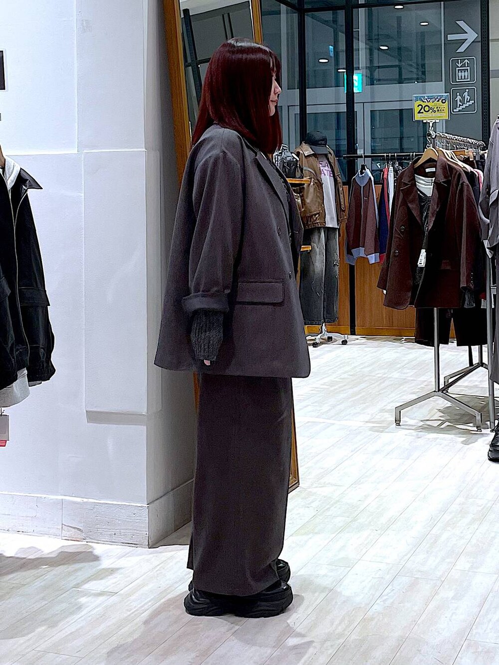 ブラック系のスニーカー、ホワイト系のTシャツ/カットソー、グレー系のテーラードジャケットを着用したレディースの秋コーディネートの3枚目の写真