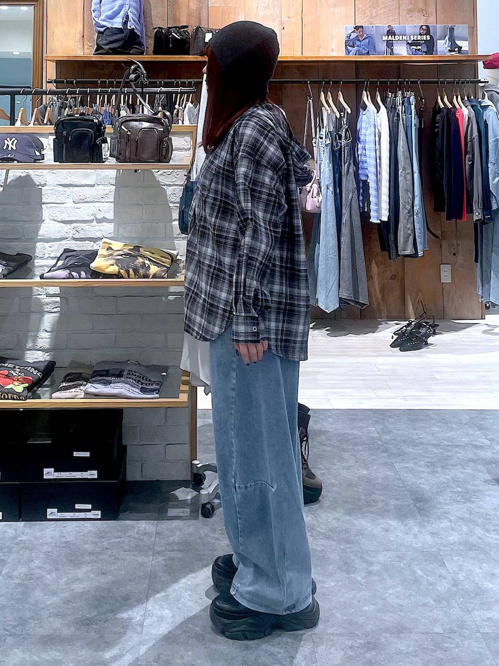 ブラック系のスニーカー、ブルー系のデニムパンツ、ブラック系のシャツ/ブラウスを着用したレディースの春コーディネートの4枚目の写真