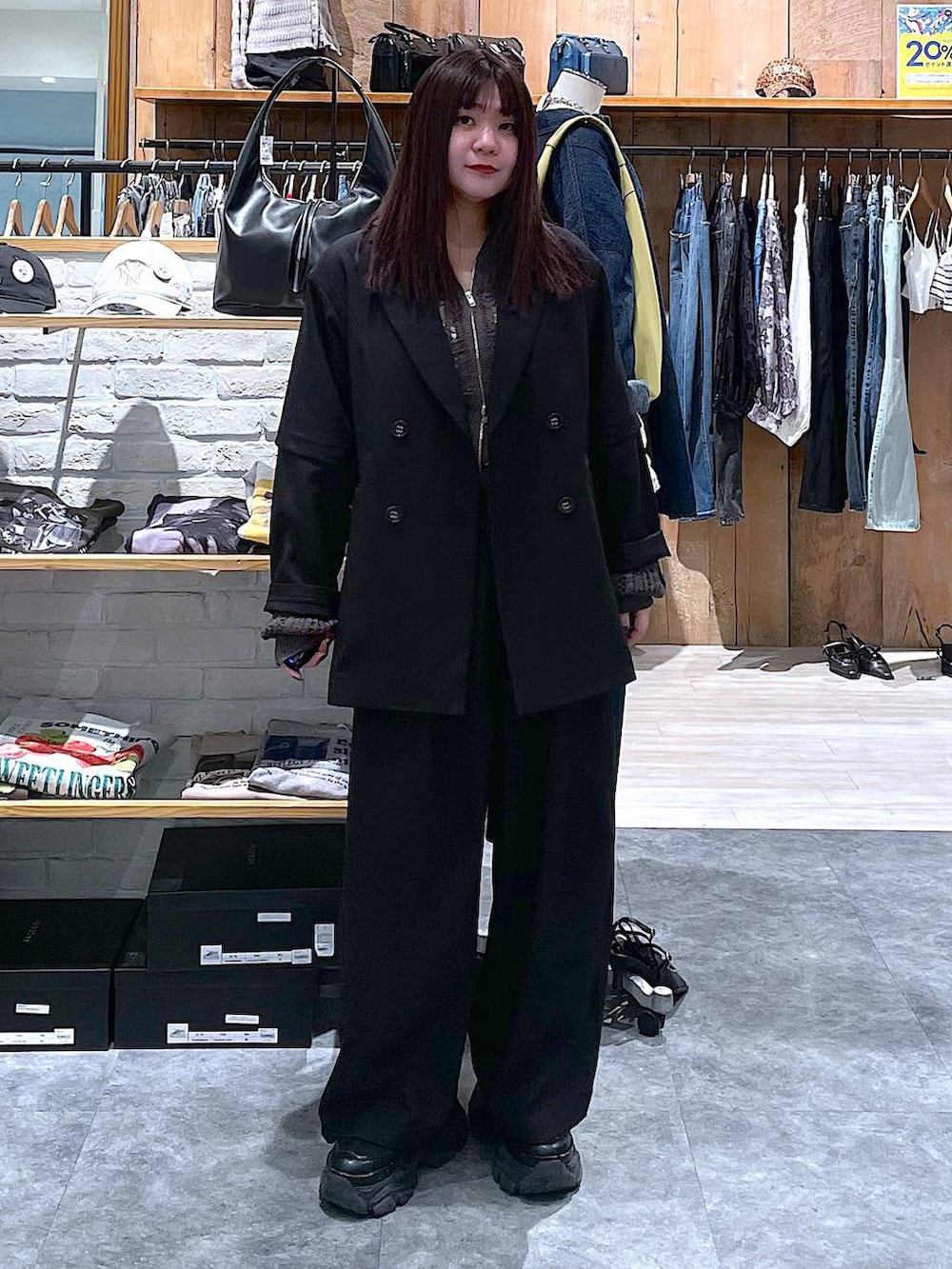 ブラック系のスニーカー、ブラック系のテーラードジャケット、グレー系のパーカーを着用したレディースの春コーディネートの5枚目の写真