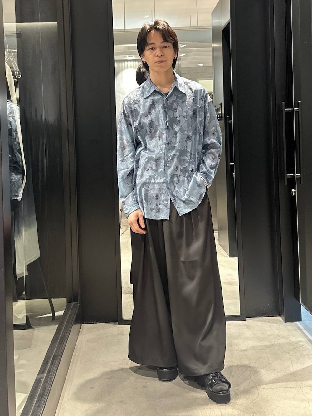 グレー系のテーラードジャケット、ブラック系のネクタイ、ブラック系のサンダルを着用したメンズの春コーディネートの2枚目の写真