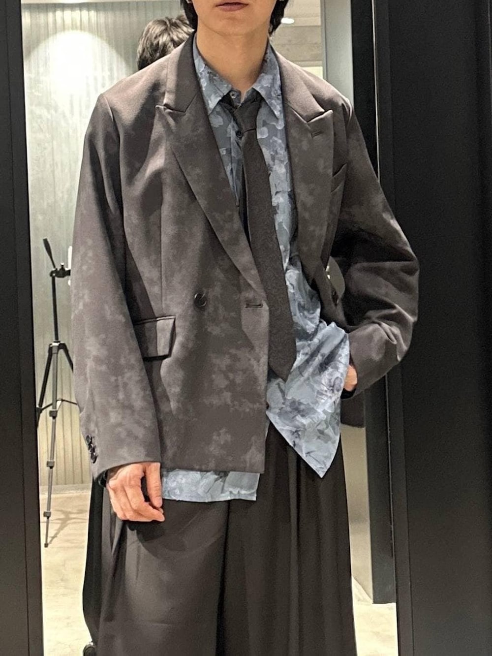 グレー系のテーラードジャケット、ブラック系のネクタイ、ブラック系のサンダルを着用したメンズの春コーディネートの3枚目の写真