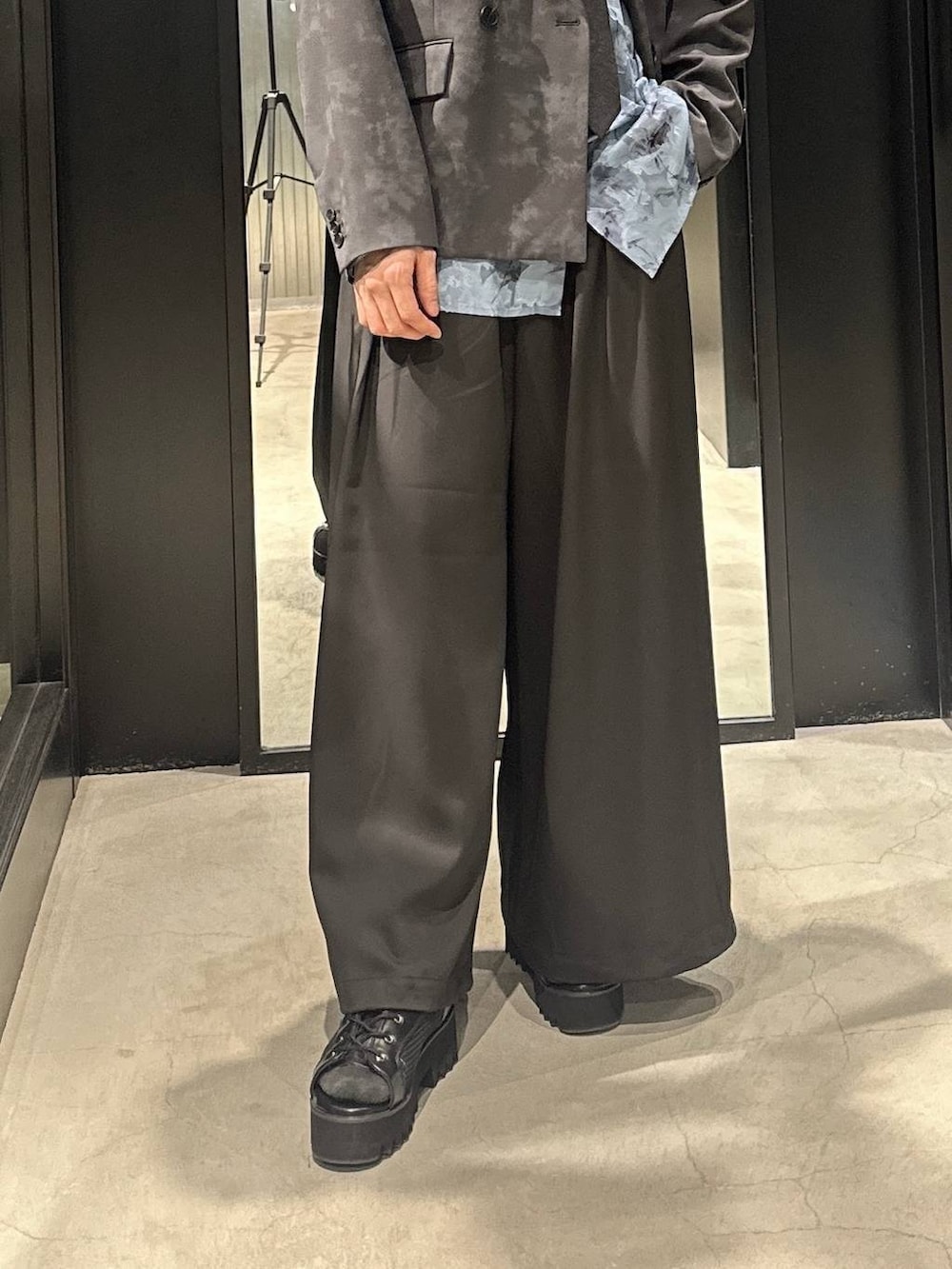 グレー系のテーラードジャケット、ブラック系のネクタイ、ブラック系のサンダルを着用したメンズの春コーディネートの6枚目の写真