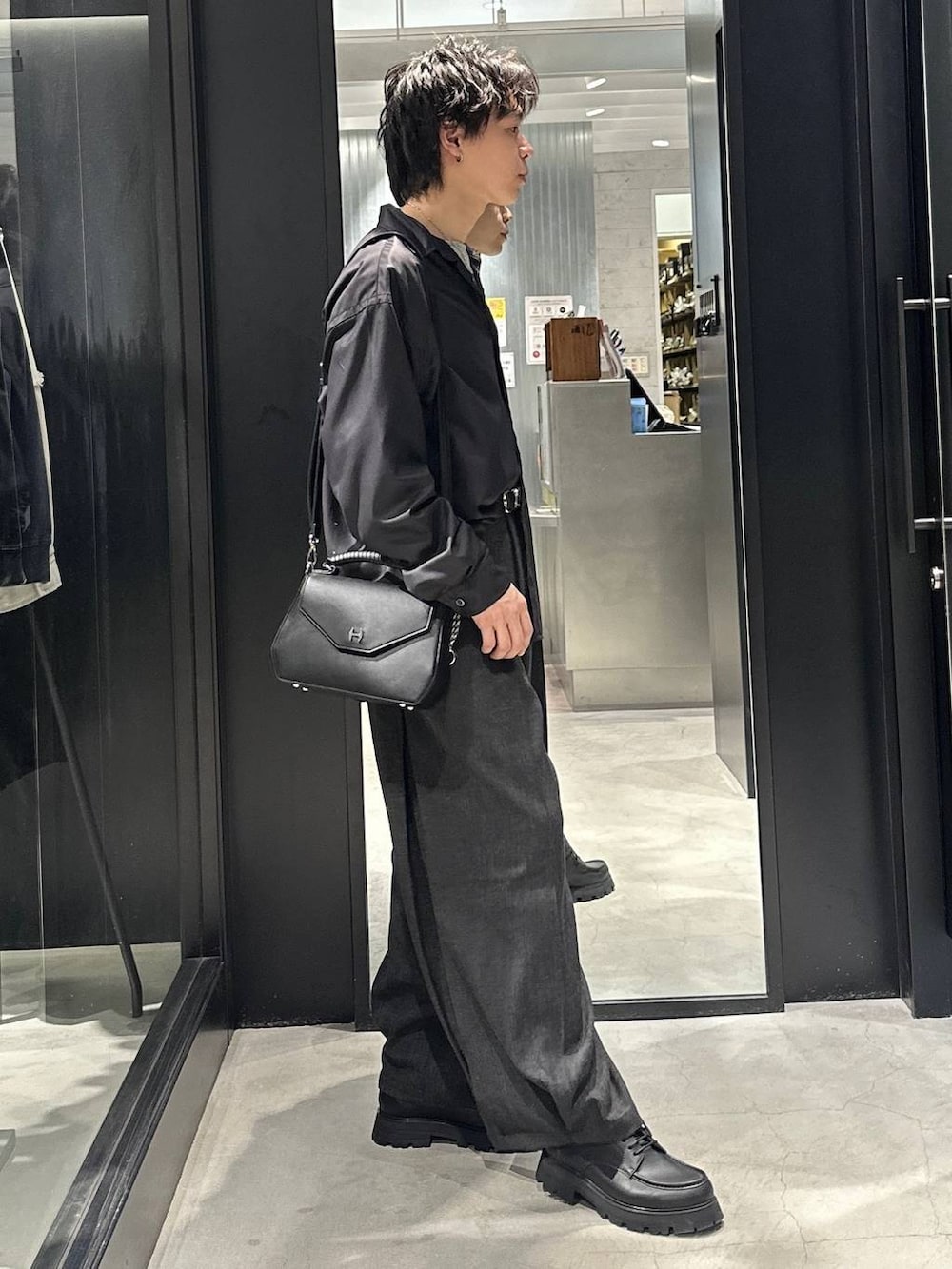 ブラック系のドレスシューズ、ブラック系のスラックス、グレー系のTシャツ/カットソーを着用したメンズの春コーディネートの4枚目の写真