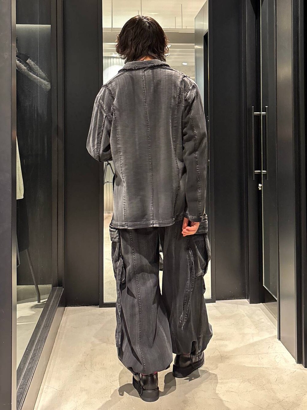 ブラック系のテーラードジャケット、ブラック系のカーゴパンツ、ブラック系のドレスシューズを着用したメンズの春コーディネートの3枚目の写真