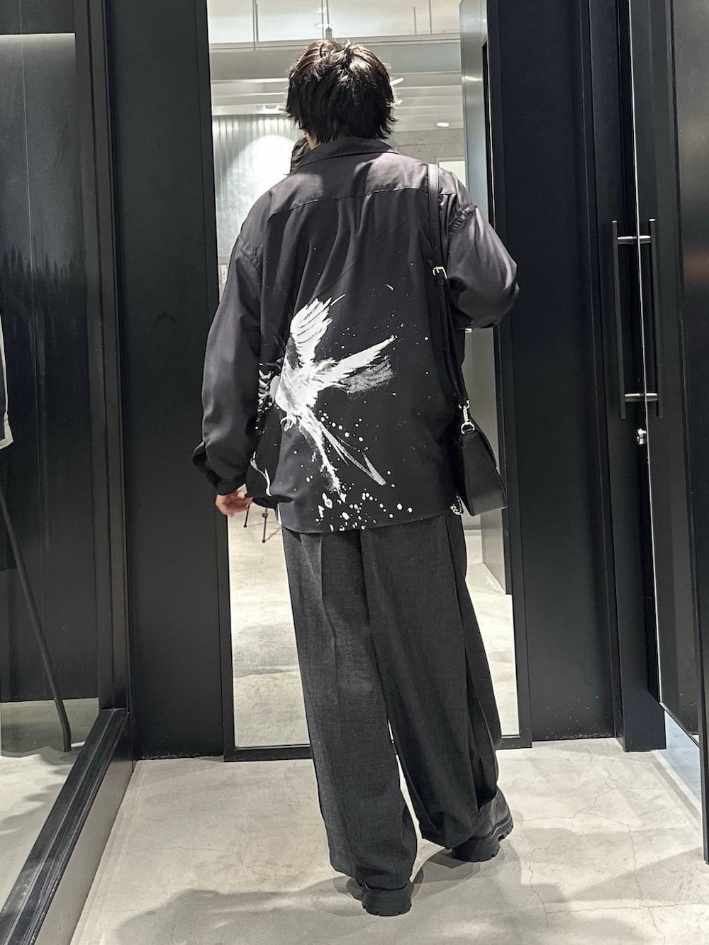 ブラック系のドレスシューズ、ブラック系のスラックス、グレー系のTシャツ/カットソーを着用したメンズの春コーディネートの2枚目の写真