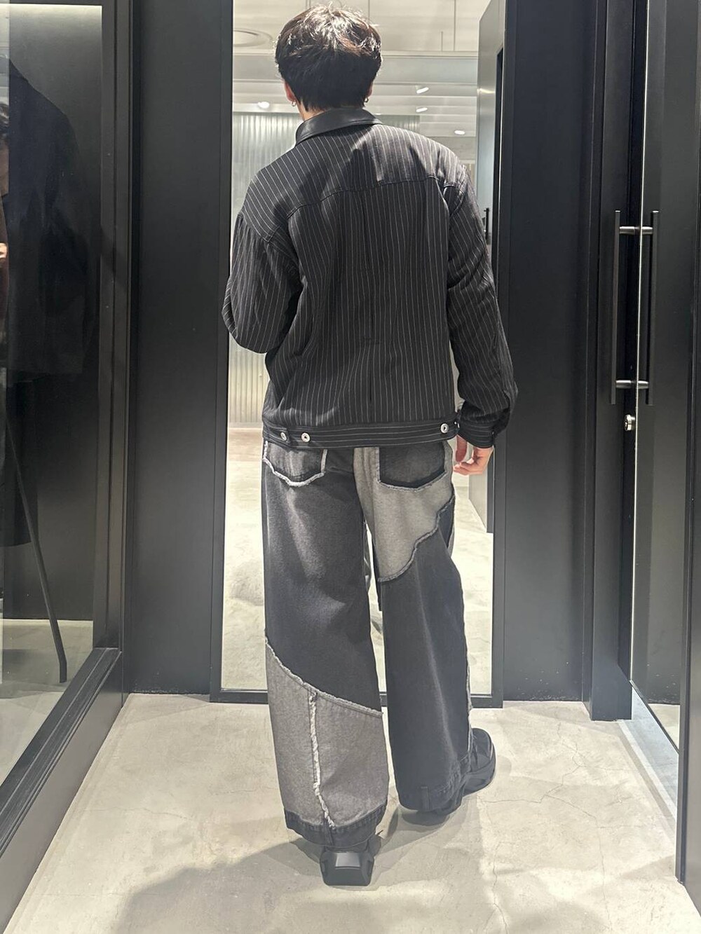 ブラック系のスニーカー、ブラック系のブルゾン、ブラック系のデニムパンツを着用したメンズの秋コーディネートの4枚目の写真