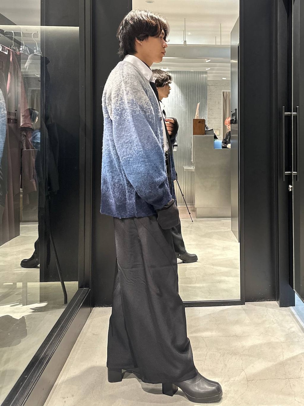 ブラック系のネクタイ、ブルー系のカーディガン/ボレロ、ブラック系のスラックスを着用したメンズの秋コーディネートの2枚目の写真