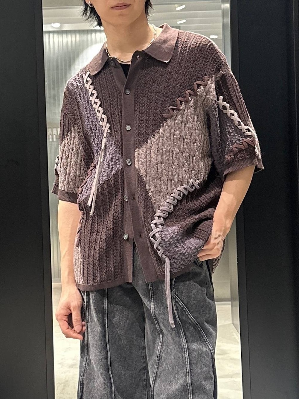 ブラック系のデニムパンツ、ブラック系のサンダル、ブラウン系のニット/セーターを着用したメンズの春コーディネートの2枚目の写真