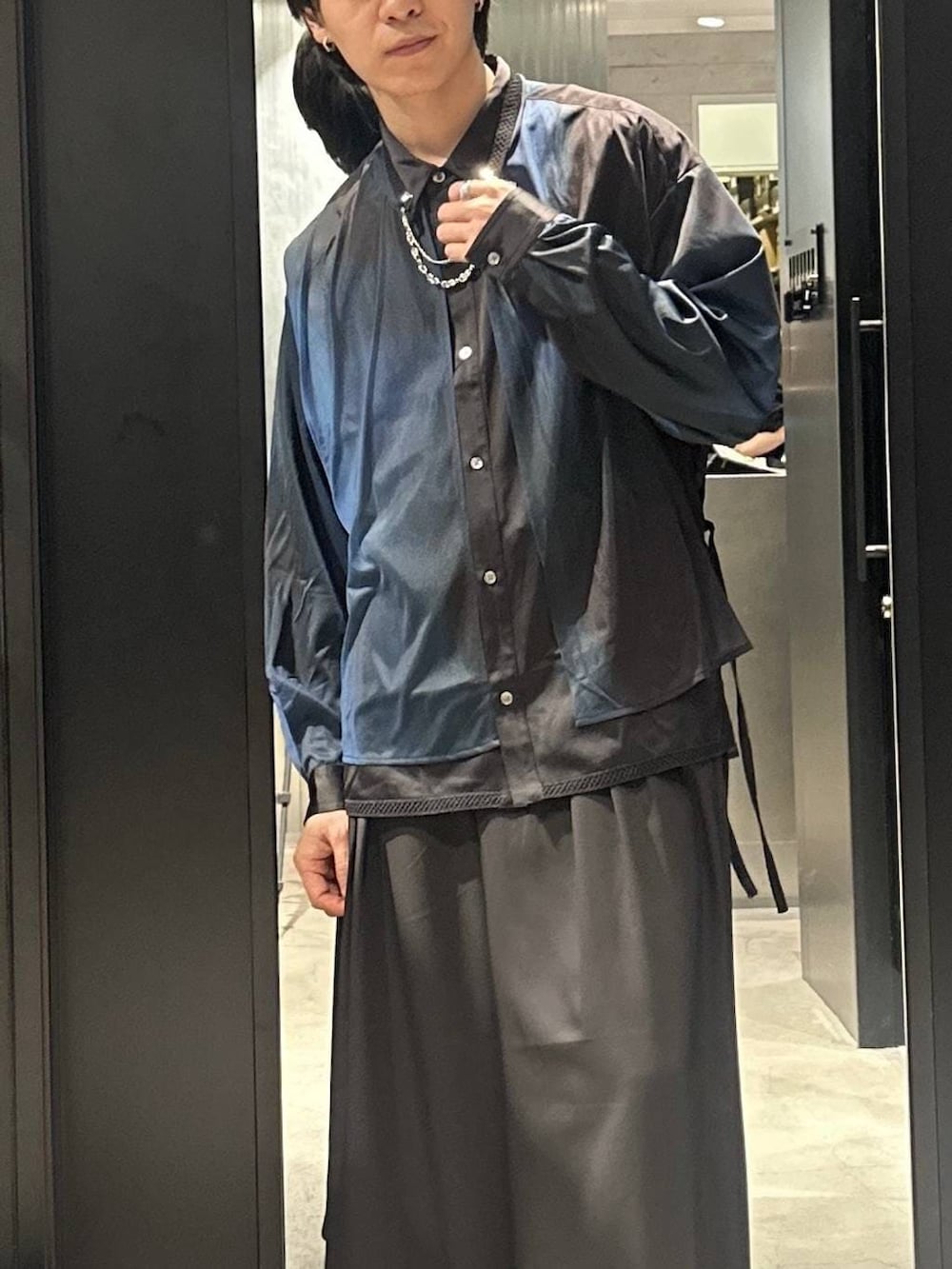 ブラック系のトレンチコート、ブラック系のサンダル、ブラック系のシャツ/ブラウスを着用したメンズの春コーディネートの9枚目の写真