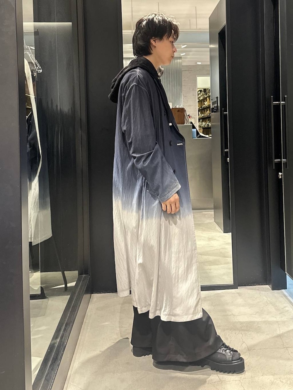 ブラック系のトレンチコート、ブラック系のサンダル、ブラック系のシャツ/ブラウスを着用したメンズの春コーディネートの2枚目の写真