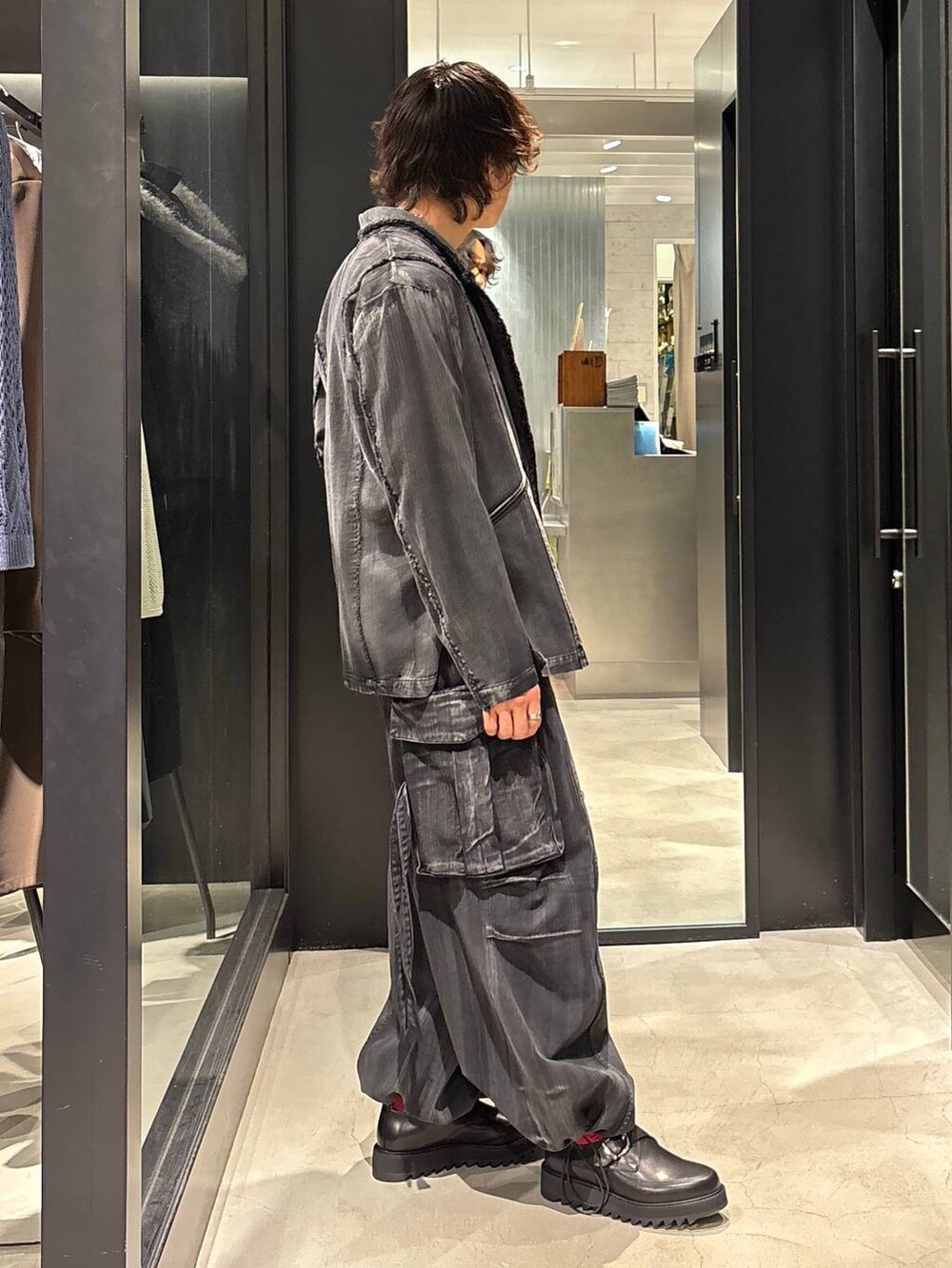 ブラック系のテーラードジャケット、ブラック系のカーゴパンツ、ブラック系のドレスシューズを着用したメンズの春コーディネートの2枚目の写真