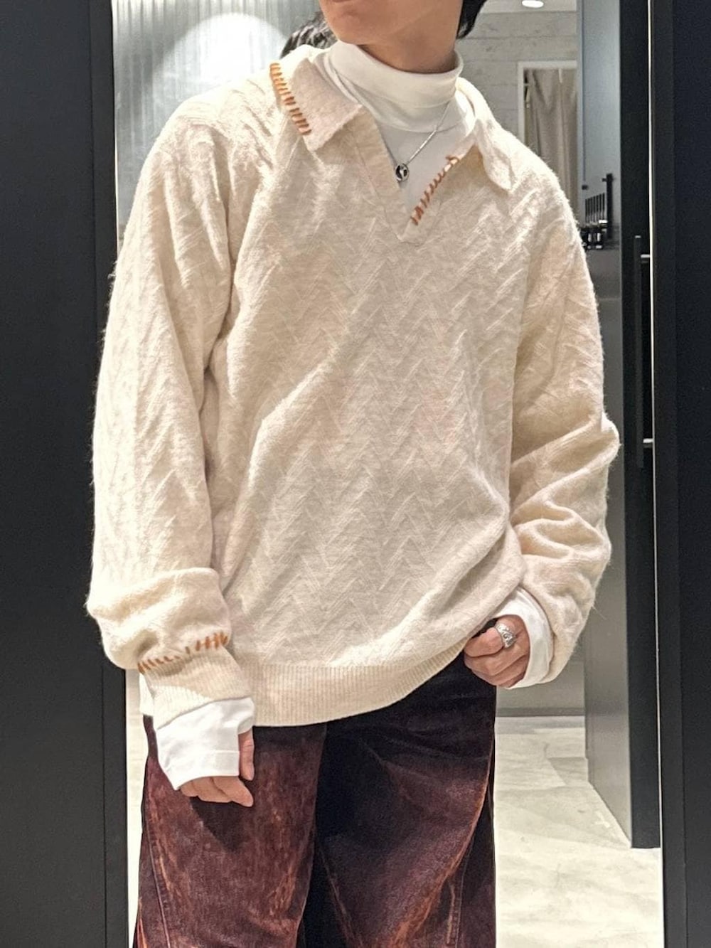 ブラック系のスニーカー、ホワイト系のTシャツ/カットソー、ホワイト系のニット/セーターを着用したメンズの冬コーディネートの3枚目の写真