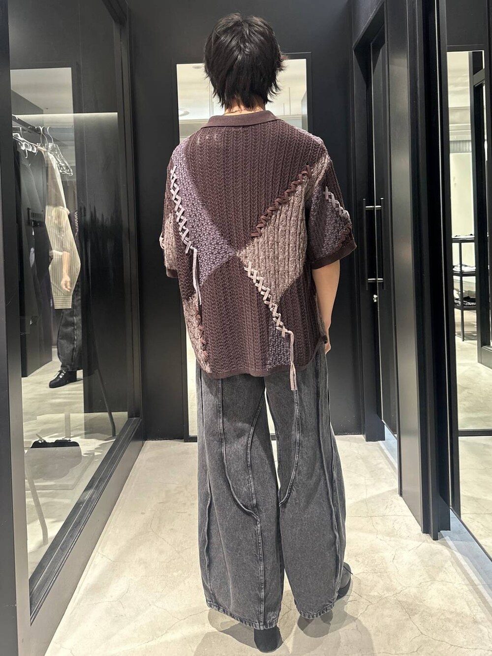 ブラック系のデニムパンツ、ブラック系のサンダル、ブラウン系のニット/セーターを着用したメンズの春コーディネートの5枚目の写真