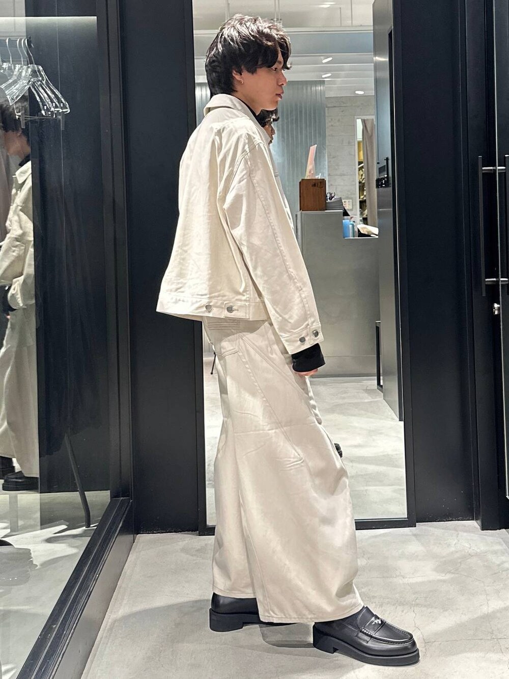 ホワイト系のデニムパンツ、ブラック系のローファー、ホワイト系のデニムジャケットを着用したメンズの秋コーディネートの2枚目の写真