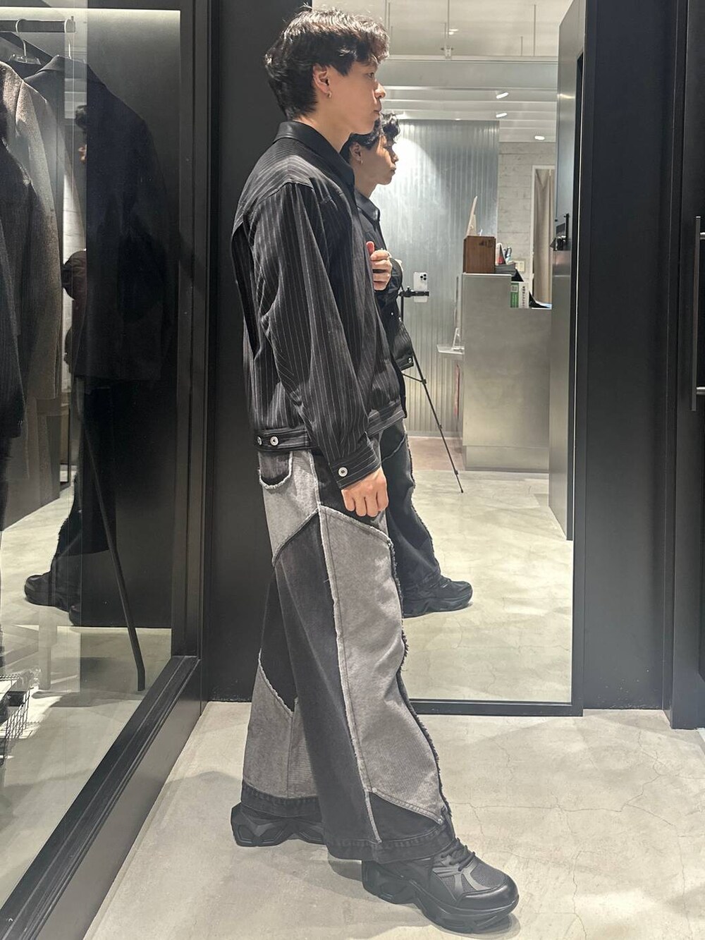 ブラック系のスニーカー、ブラック系のブルゾン、ブラック系のデニムパンツを着用したメンズの秋コーディネートの3枚目の写真