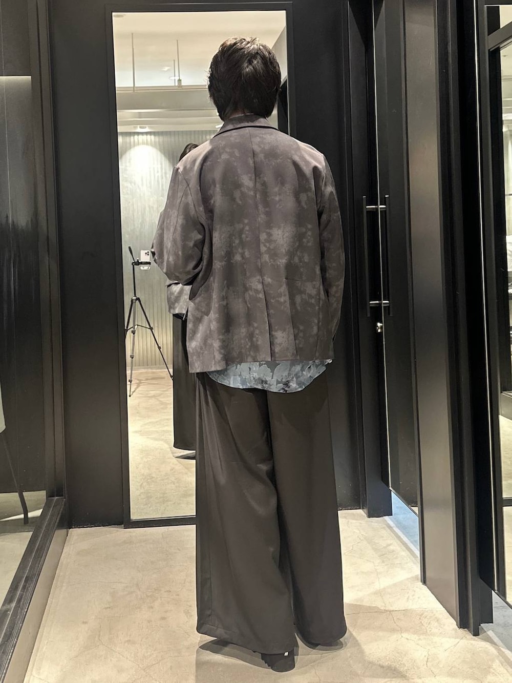 グレー系のテーラードジャケット、ブラック系のネクタイ、ブラック系のサンダルを着用したメンズの春コーディネートの5枚目の写真