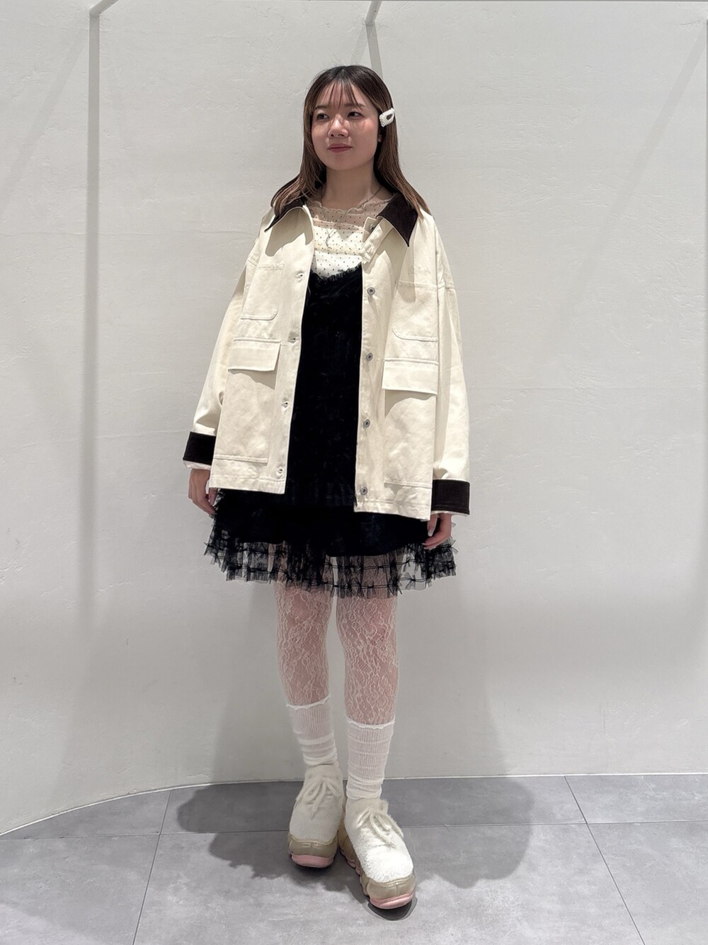 ホワイト系のブルゾン、ブラック系のワンピース、ホワイト系のTシャツ/カットソーを着用したレディースの春コーディネートの2枚目の写真
