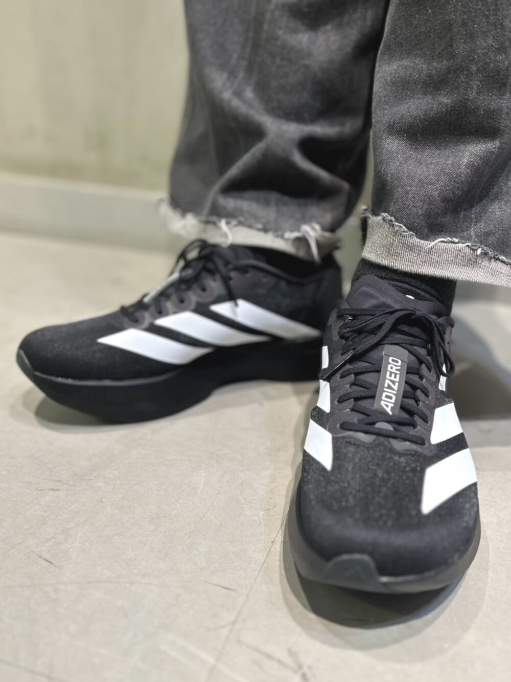 レッド系のTシャツ/カットソー、ホワイト系のスニーカーを着用したメンズの夏コーディネートの2枚目の写真