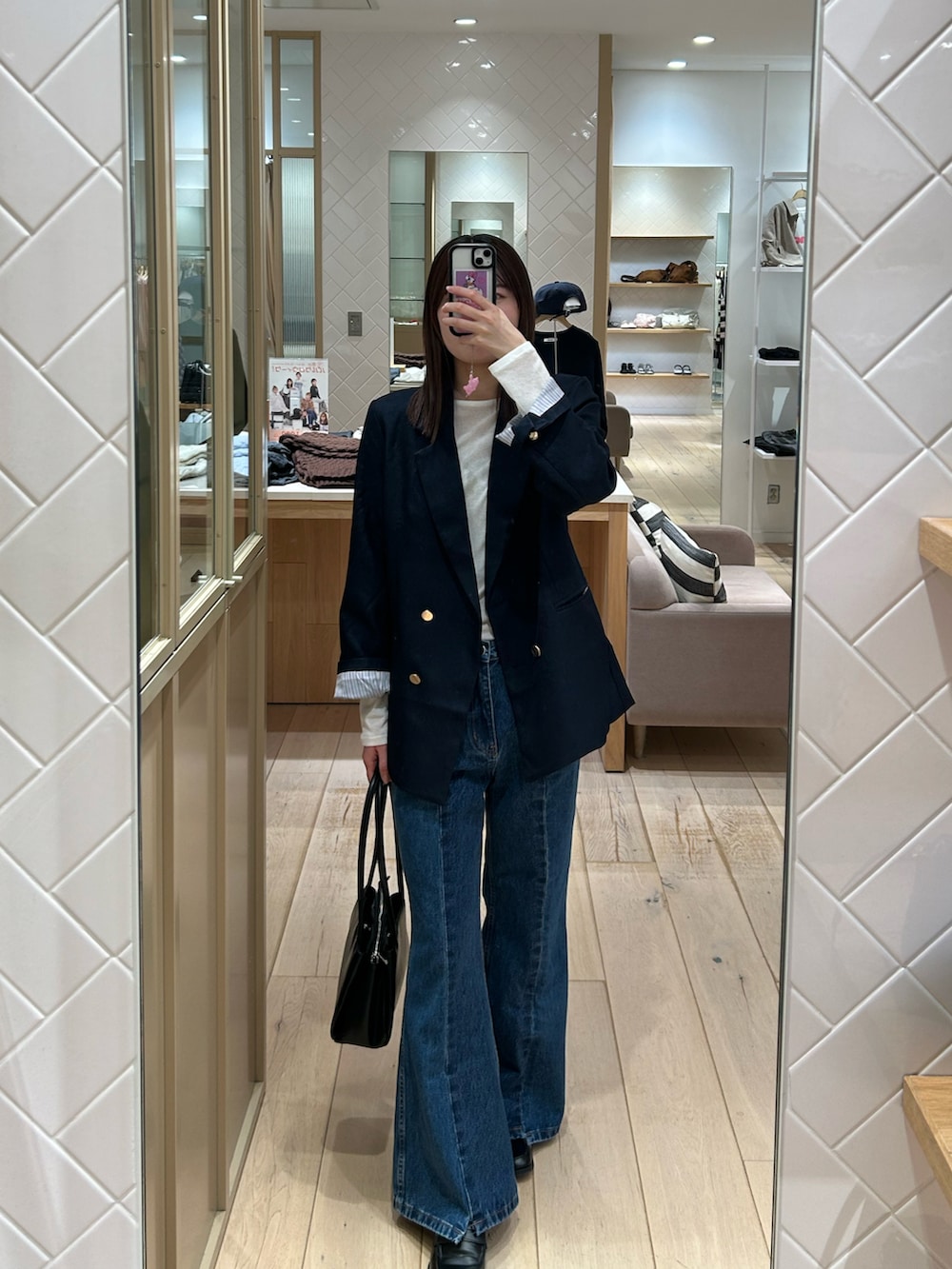 ブルー系のテーラードジャケット、ブルー系のデニムパンツ、ブラック系のショルダーバッグを着用したレディースの秋コーディネートの3枚目の写真