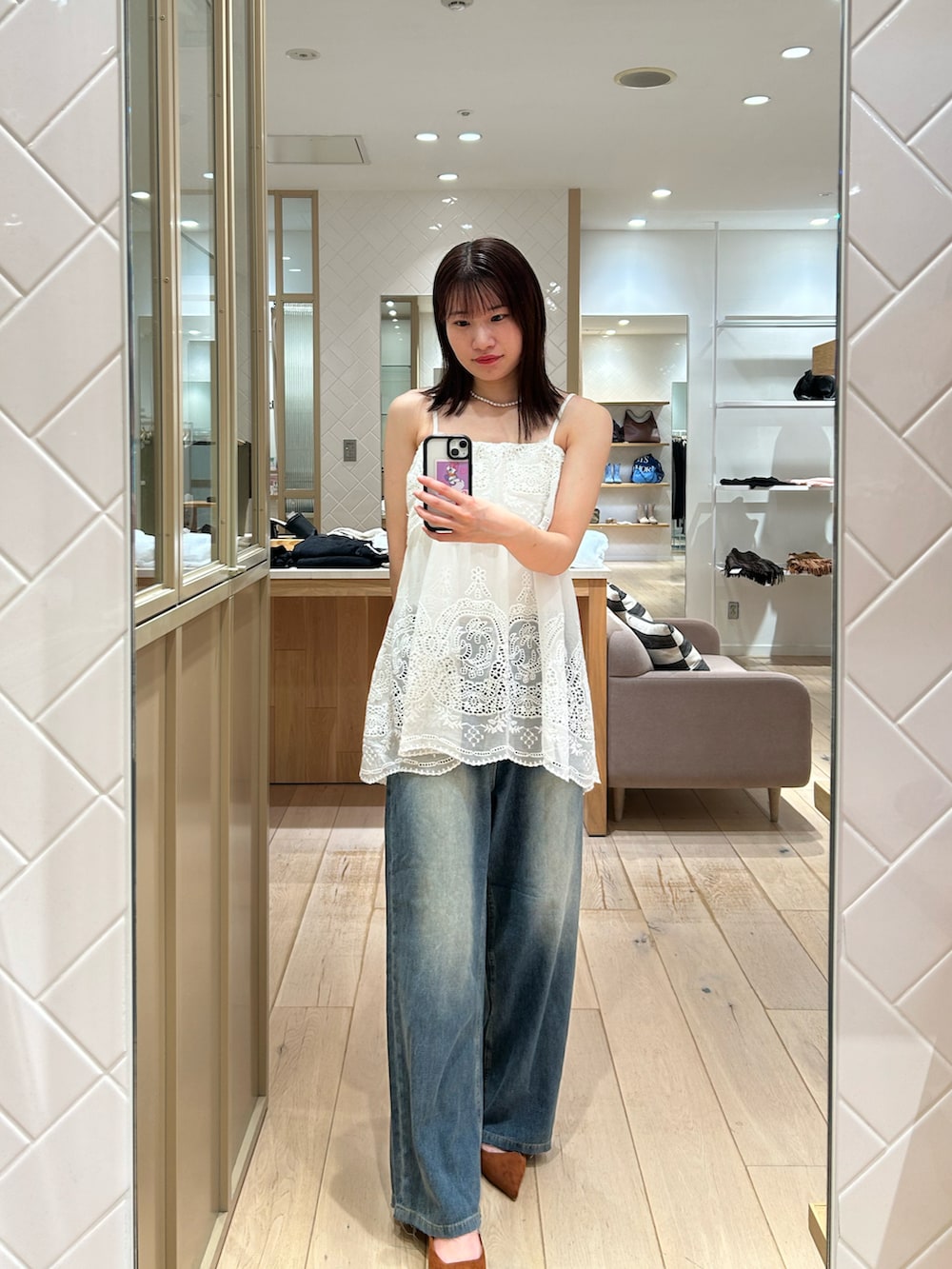 ホワイト系のシャツ/ブラウス、グレー系のカーディガン/ボレロ、ブルー系のデニムパンツを着用したレディースの秋コーディネートの3枚目の写真