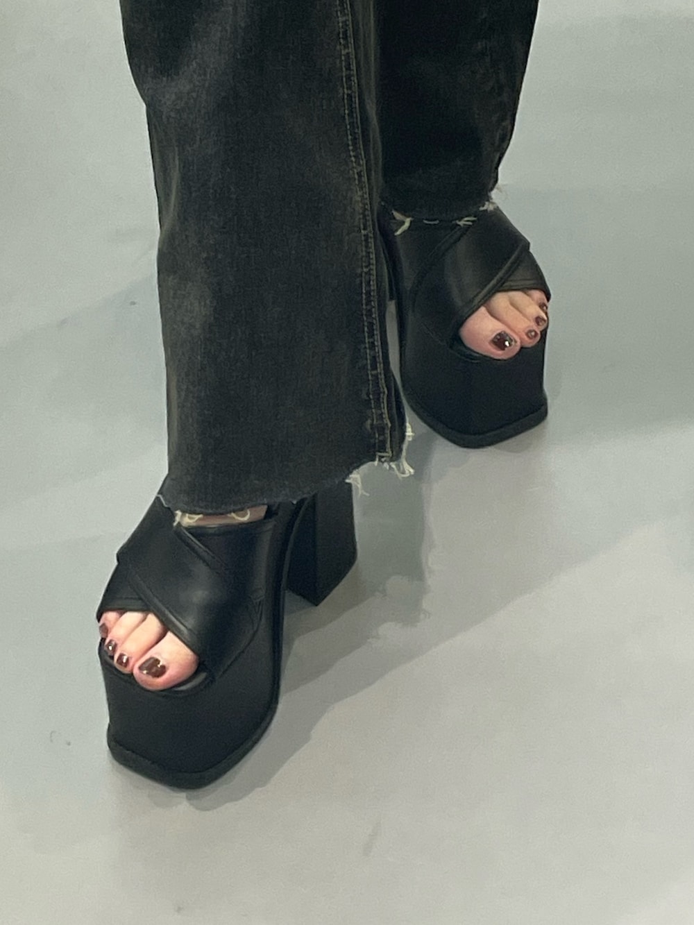 ブラック系のTシャツ/カットソー、ブルー系のデニムパンツ、ブラック系のサンダルを着用したレディースの春コーディネートの5枚目の写真