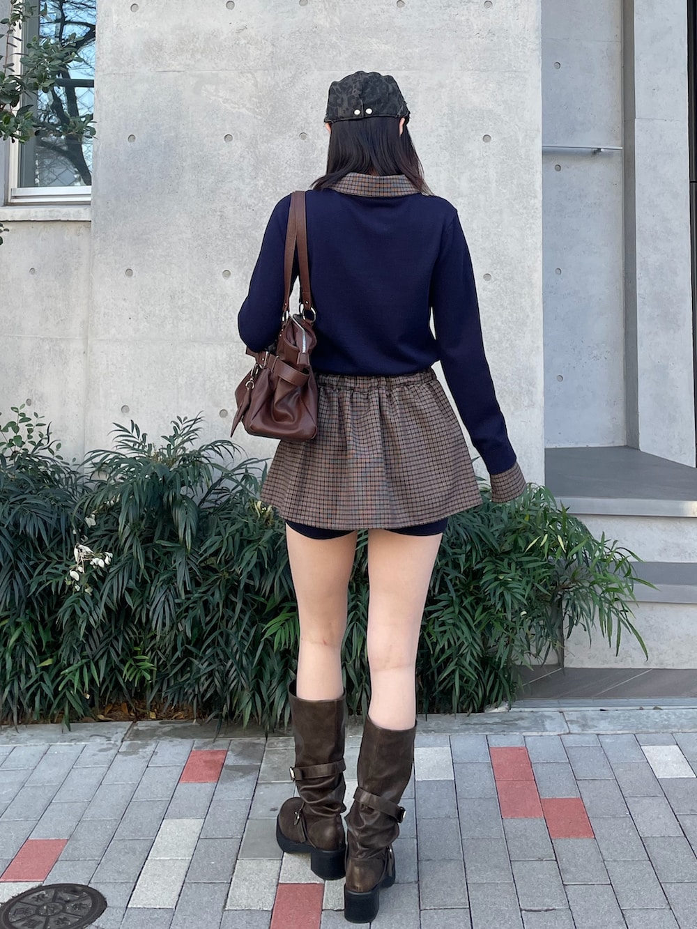 ブルー系のスカート、ブラック系のトートバッグ、ブラウン系のブーツを着用したレディースの冬コーディネートの4枚目の写真