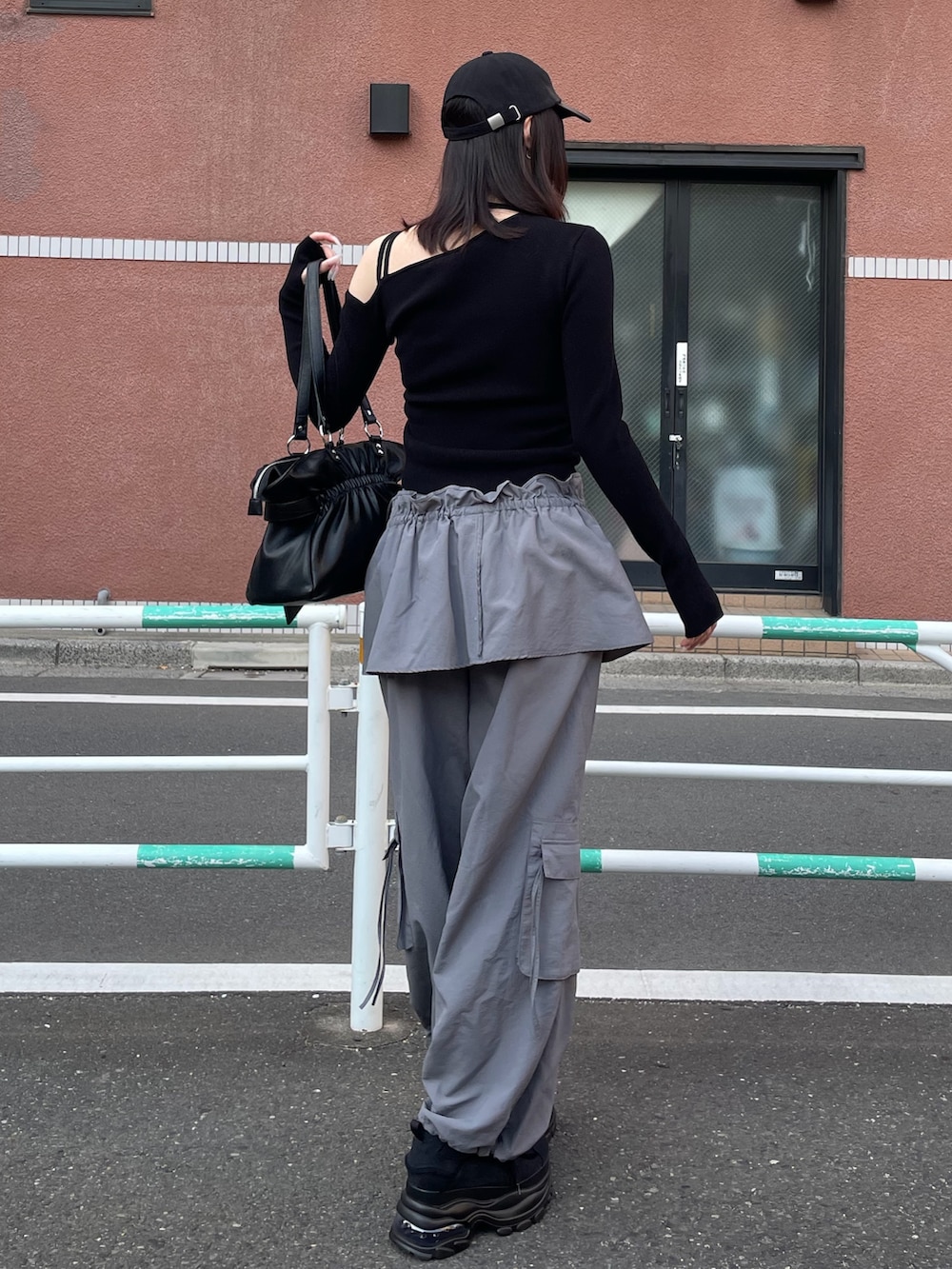 ブラック系のニット/セーター、グレー系のその他パンツ、ブラック系のトートバッグを着用したレディースの冬コーディネートの3枚目の写真