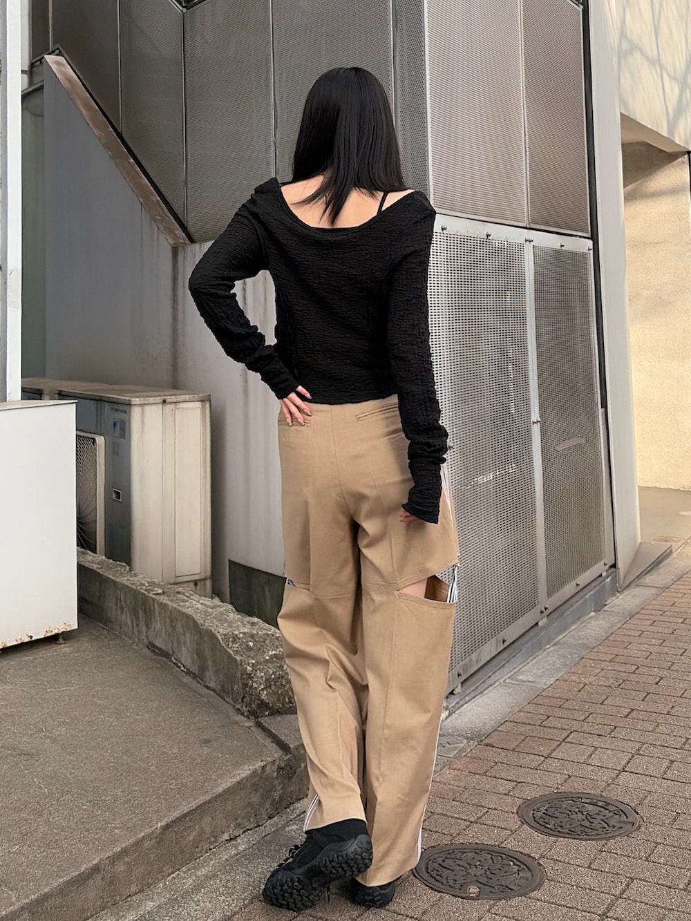 ブラック系のTシャツ/カットソー、ベージュ系のその他パンツ、ブラック系のスニーカーを着用したレディースの春コーディネートの4枚目の写真