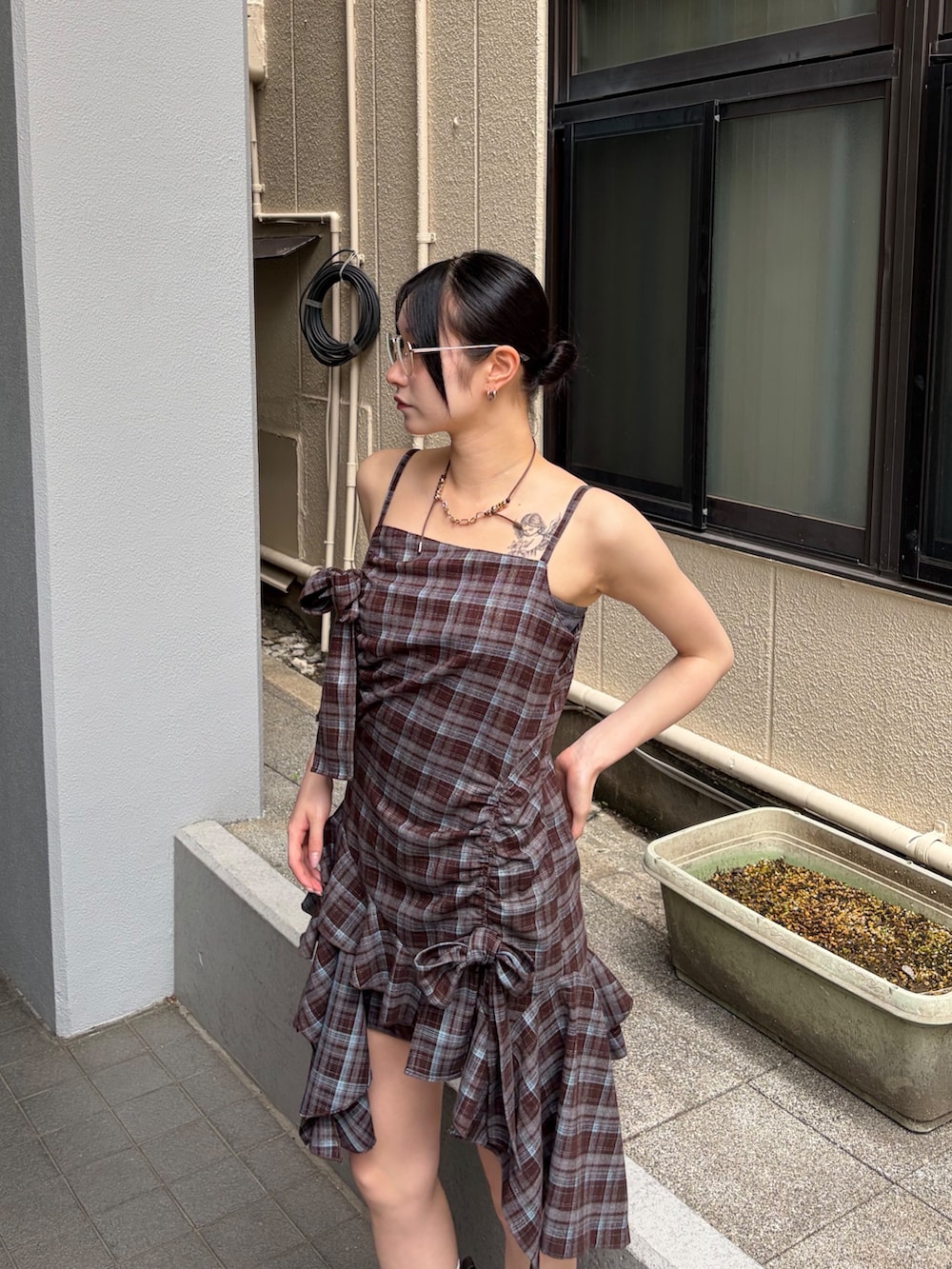 ブラウン系のワンピース、ブラウン系のブーツ、シルバー系のサングラスを着用したレディースの夏コーディネートの6枚目の写真