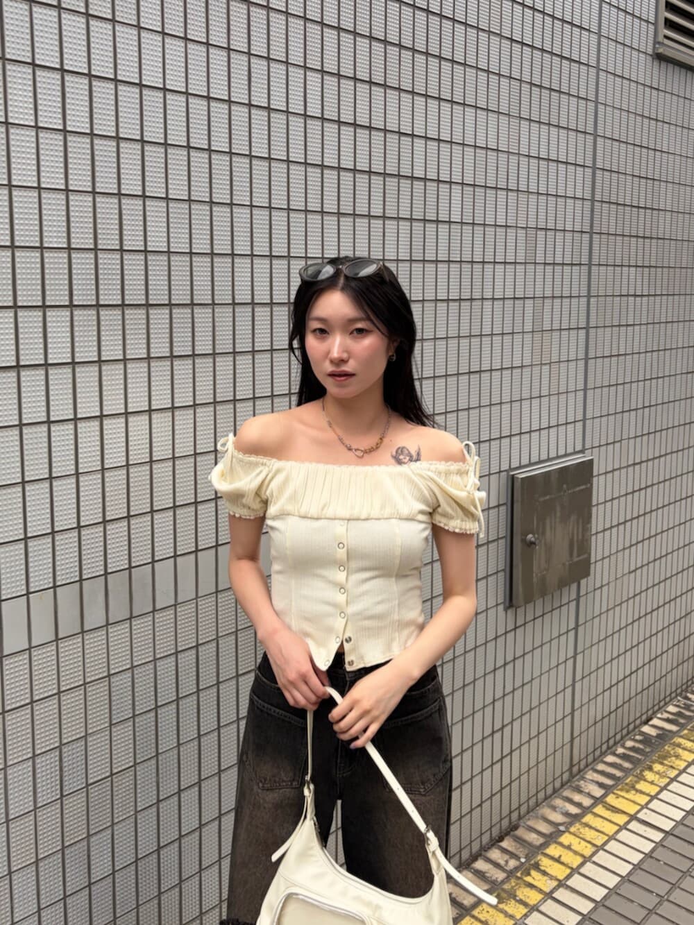 ブラック系のサンダル、ホワイト系のハンドバッグ、ホワイト系のTシャツ/カットソーを着用したレディースの夏コーディネートの5枚目の写真