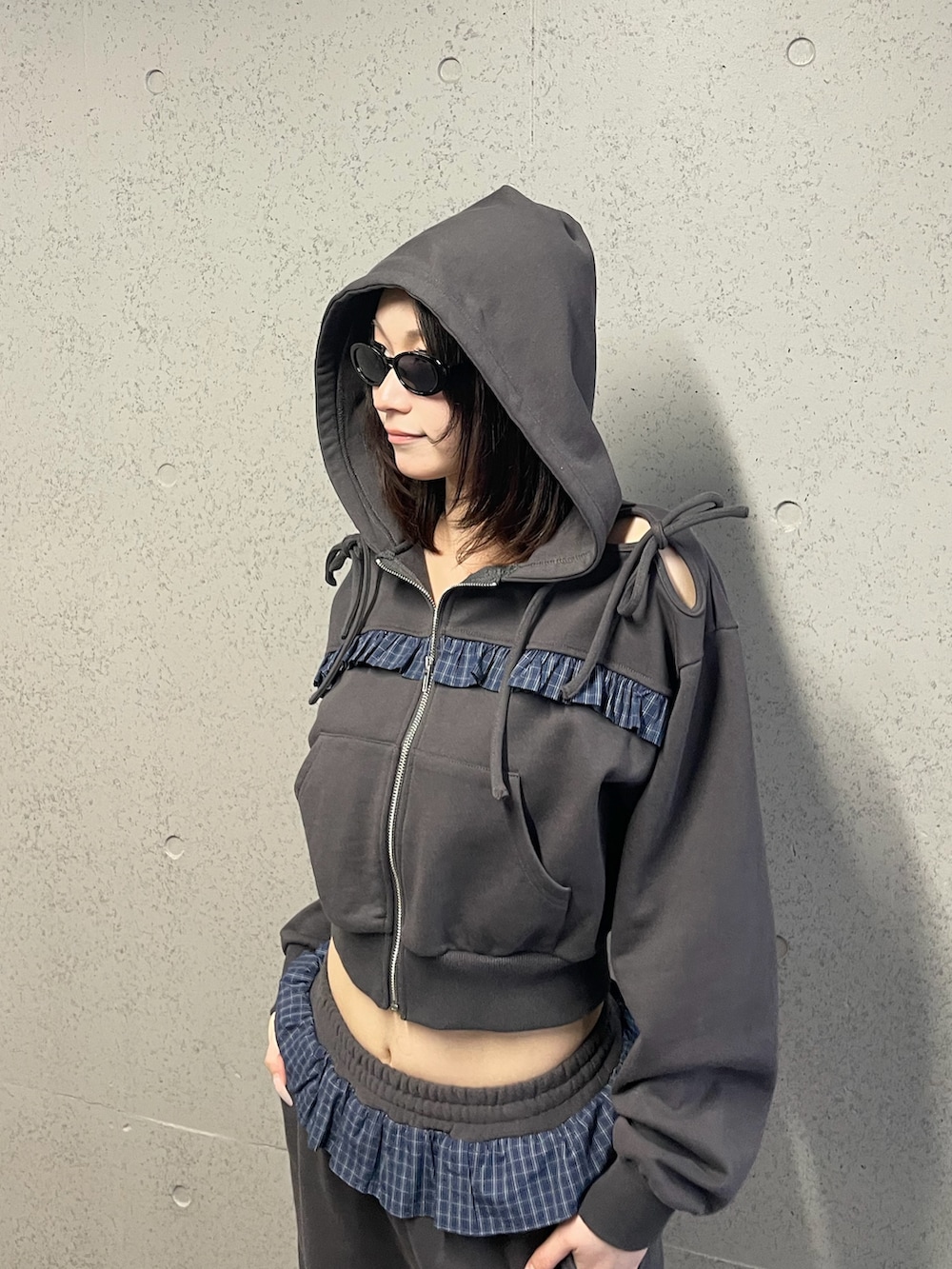 グレー系のパーカー、グレー系のスウェットパンツ、ブラック系のスニーカーを着用したレディースの冬コーディネートの5枚目の写真