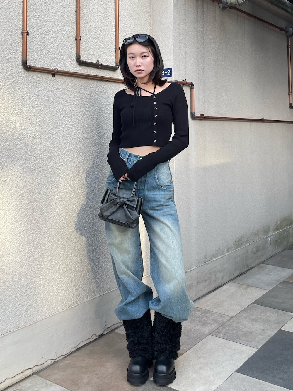 ブラック系のニット/セーター、ブルー系のデニムパンツ、ブラック系のブーツを着用したレディースの冬コーディネートの3枚目の写真