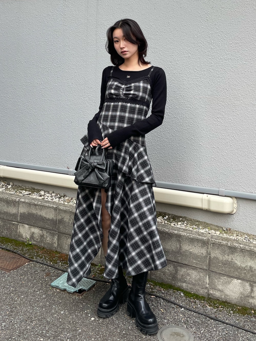 ブラック系のニット/セーター、ブラック系のワンピース、ブラック系のハンドバッグを着用したレディースの冬コーディネートの4枚目の写真