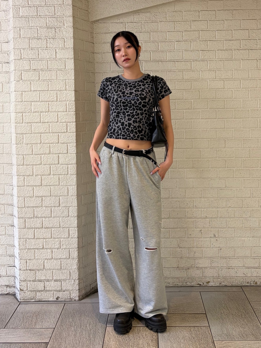 グレー系のTシャツ/カットソー、グレー系のスウェットパンツ、ブラック系のショルダーバッグを着用したレディースの夏コーディネートの4枚目の写真