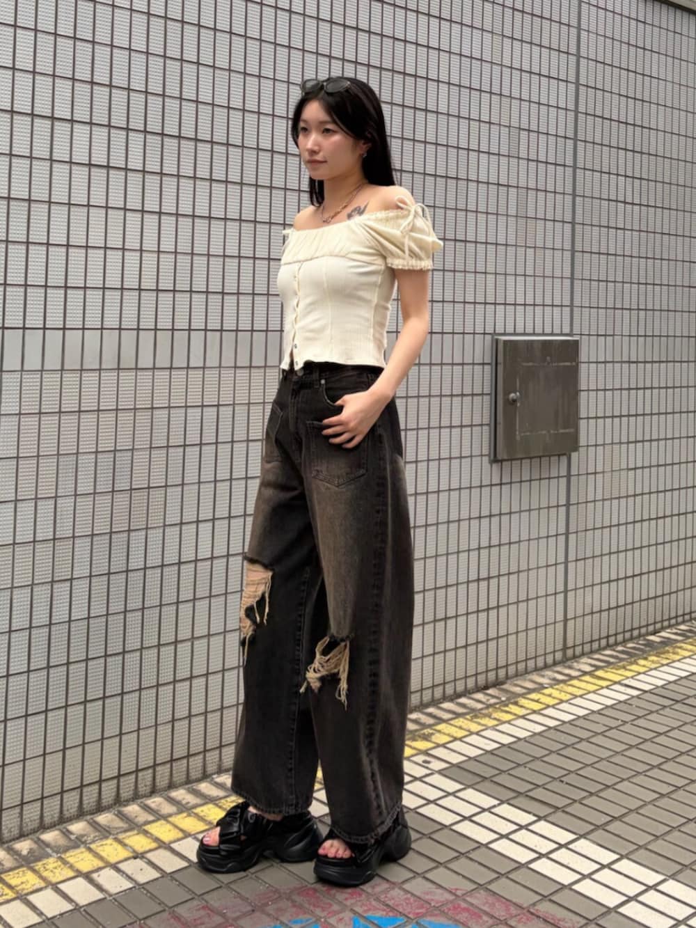 ブラック系のサンダル、ホワイト系のハンドバッグ、ホワイト系のTシャツ/カットソーを着用したレディースの夏コーディネートの4枚目の写真