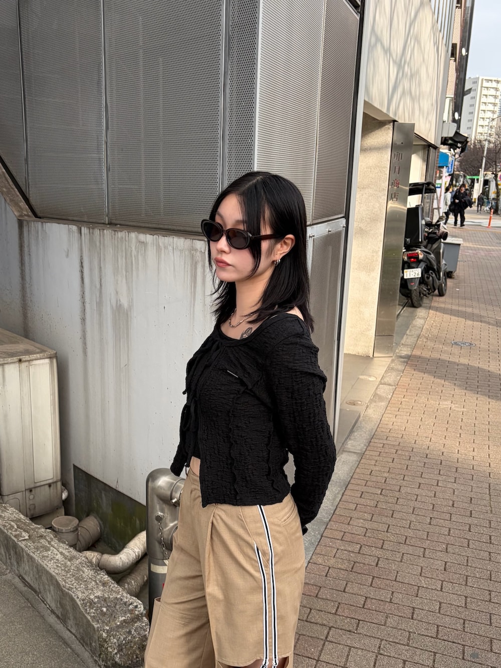 ブラック系のTシャツ/カットソー、ベージュ系のその他パンツ、ブラック系のスニーカーを着用したレディースの春コーディネートの6枚目の写真