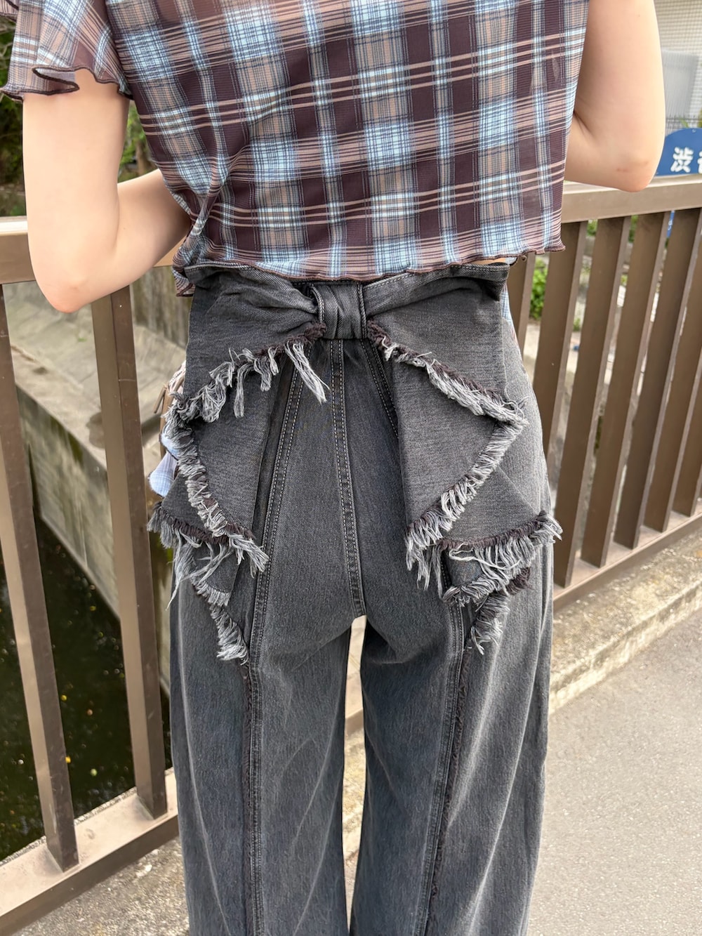 ブラック系のキャミソール、ブラウン系のTシャツ/カットソー、ブラウン系のハンドバッグを着用したレディースの春コーディネートの7枚目の写真