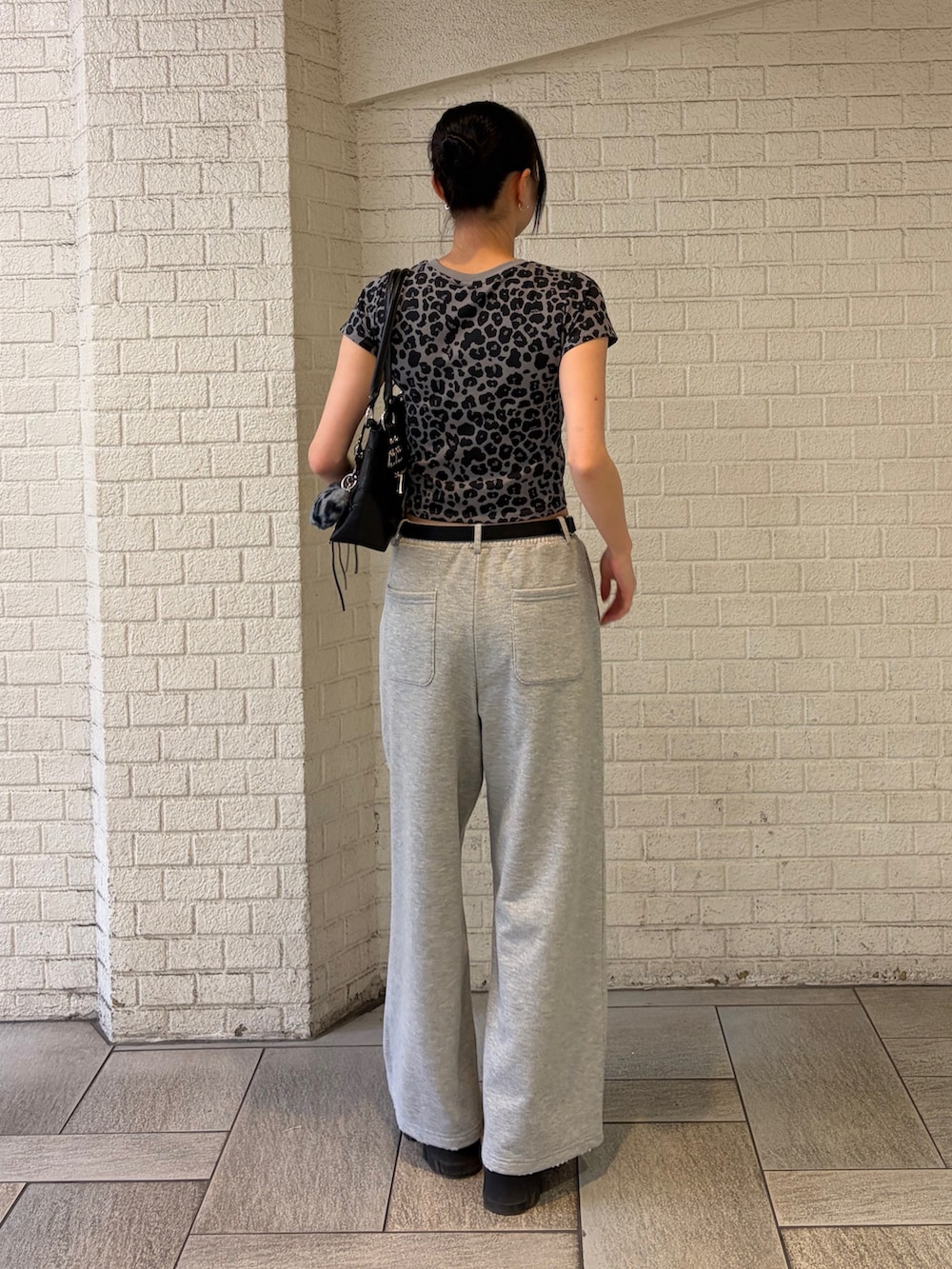 グレー系のTシャツ/カットソー、グレー系のスウェットパンツ、ブラック系のショルダーバッグを着用したレディースの夏コーディネートの3枚目の写真