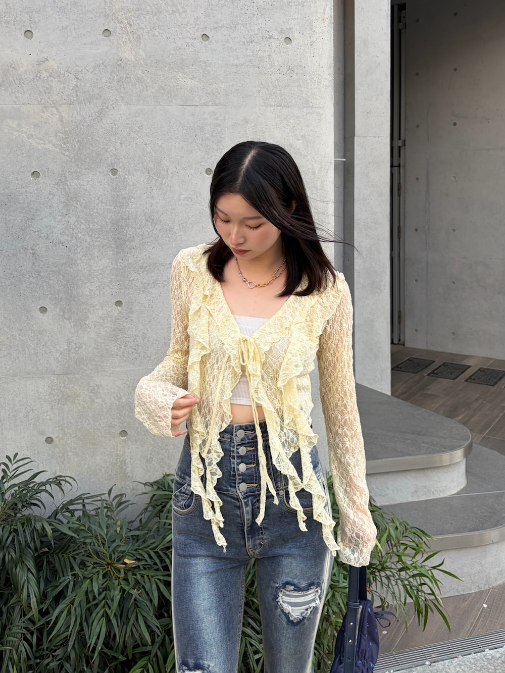 イエロー系のTシャツ/カットソー、ホワイト系のキャミソール、ブルー系のデニムパンツを着用したレディースの春コーディネートの4枚目の写真