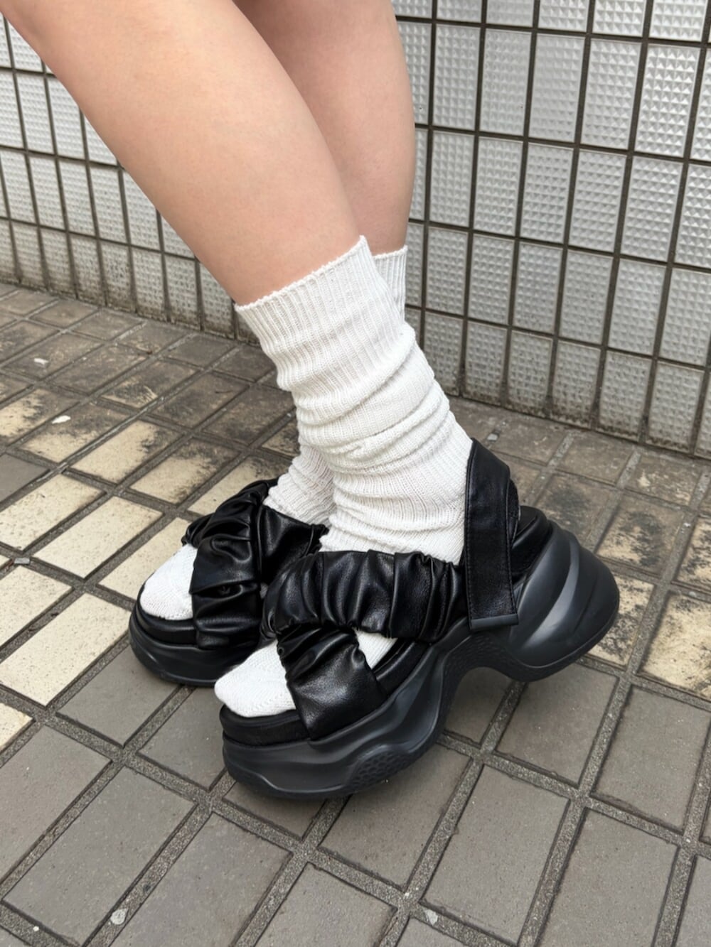 ブラック系のサンダル、ブラック系のタンクトップ、ベージュ系のスカートを着用したレディースの夏コーディネートの6枚目の写真